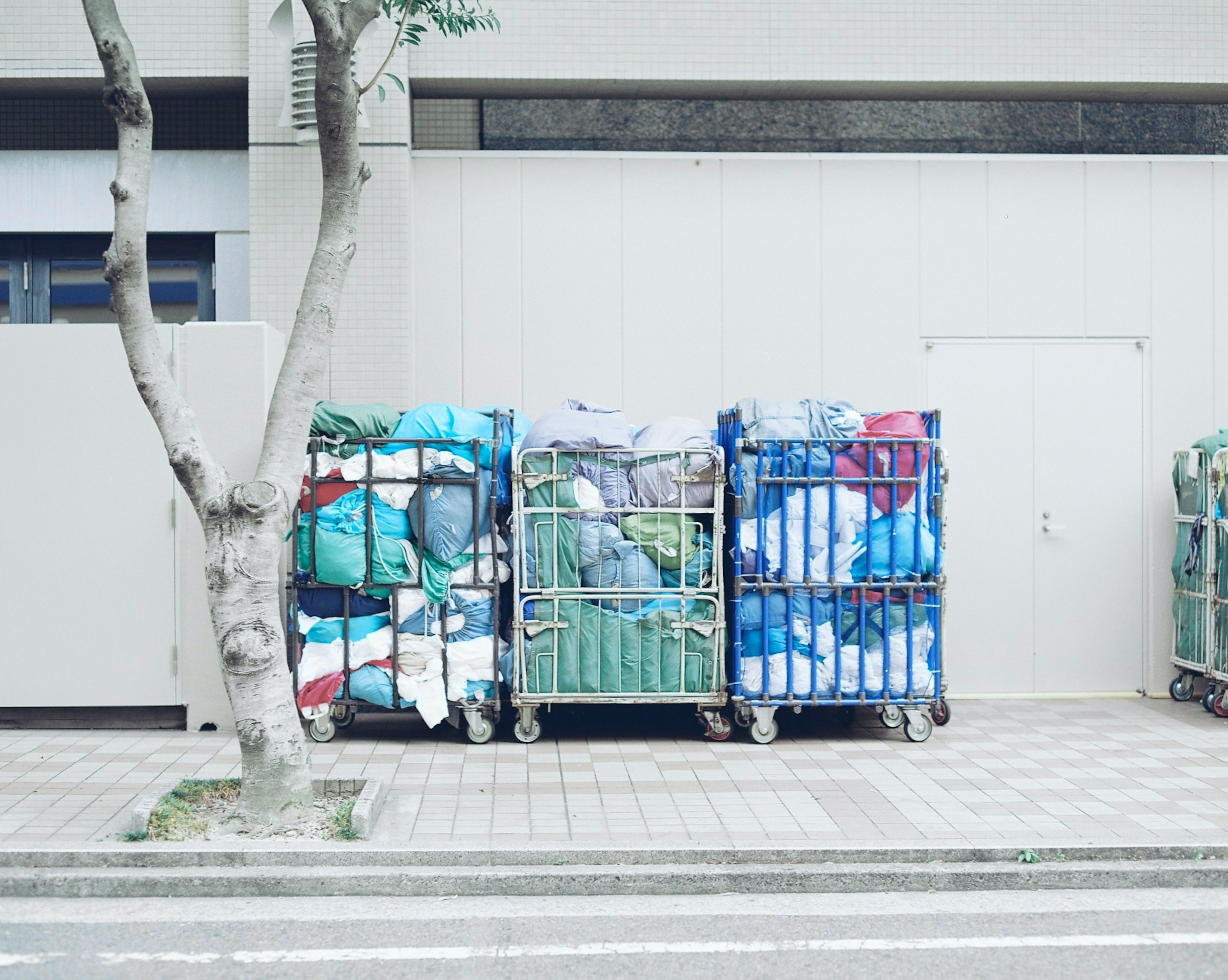 Bacs de recyclage remplis de tissus colorés dans un cadre urbain