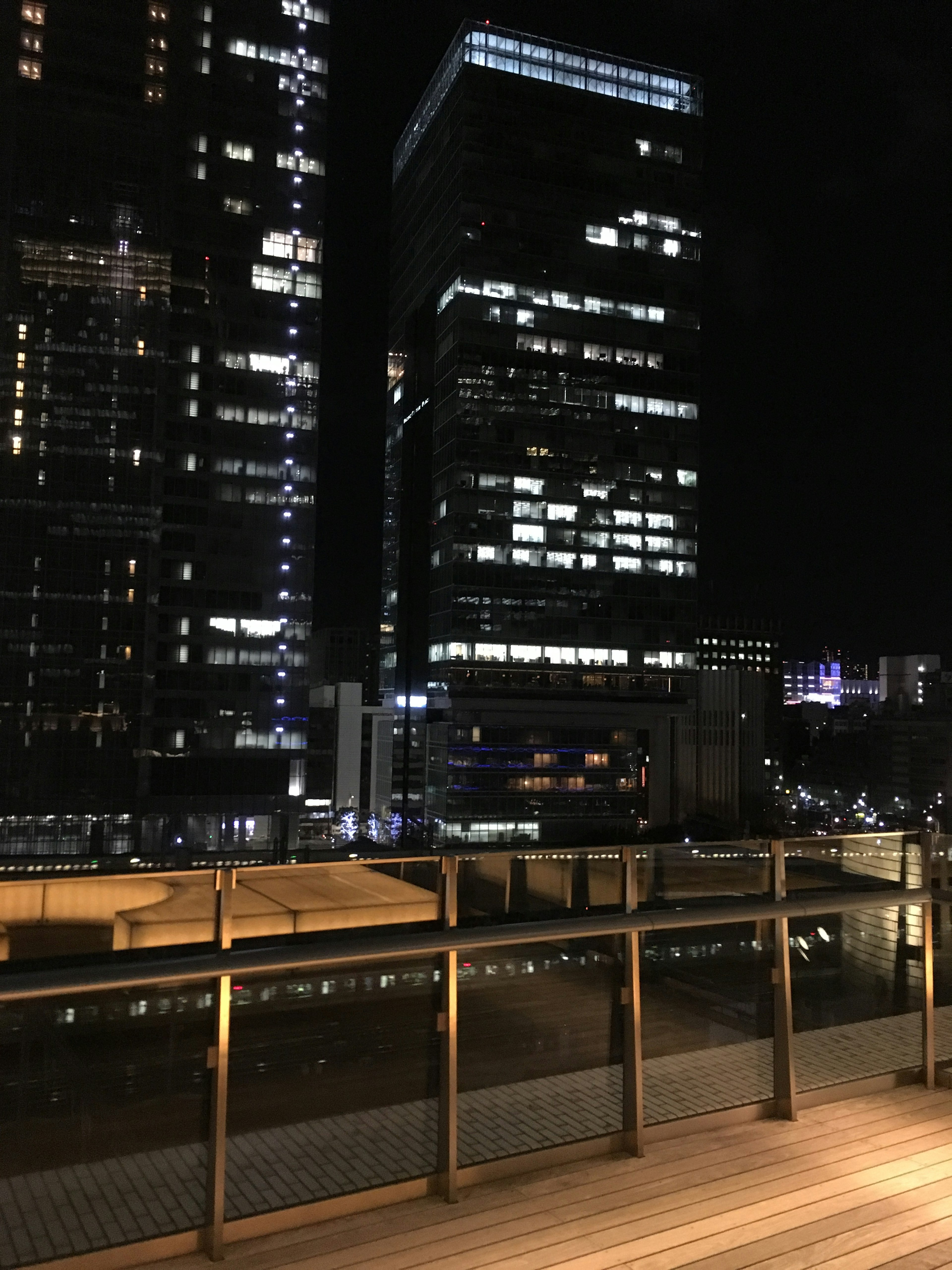 Pemandangan malam gedung pencakar langit dan pagar balkon