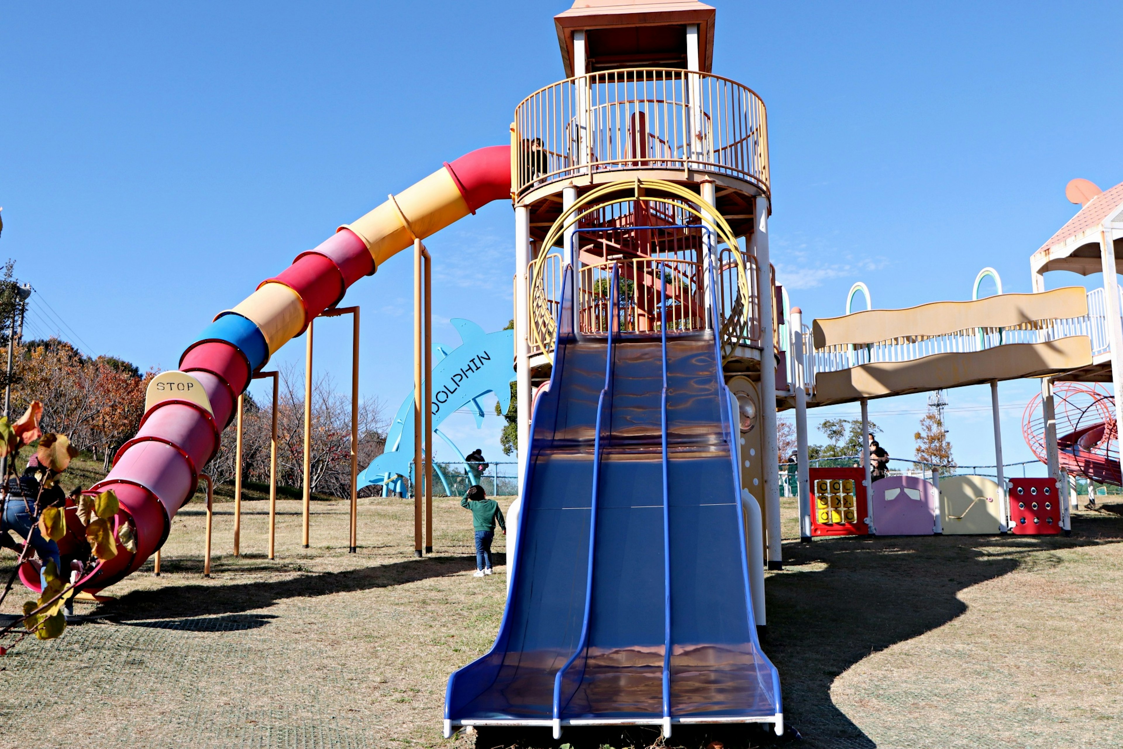 Parque infantil colorido con un tobogán azul y un tobogán en espiral