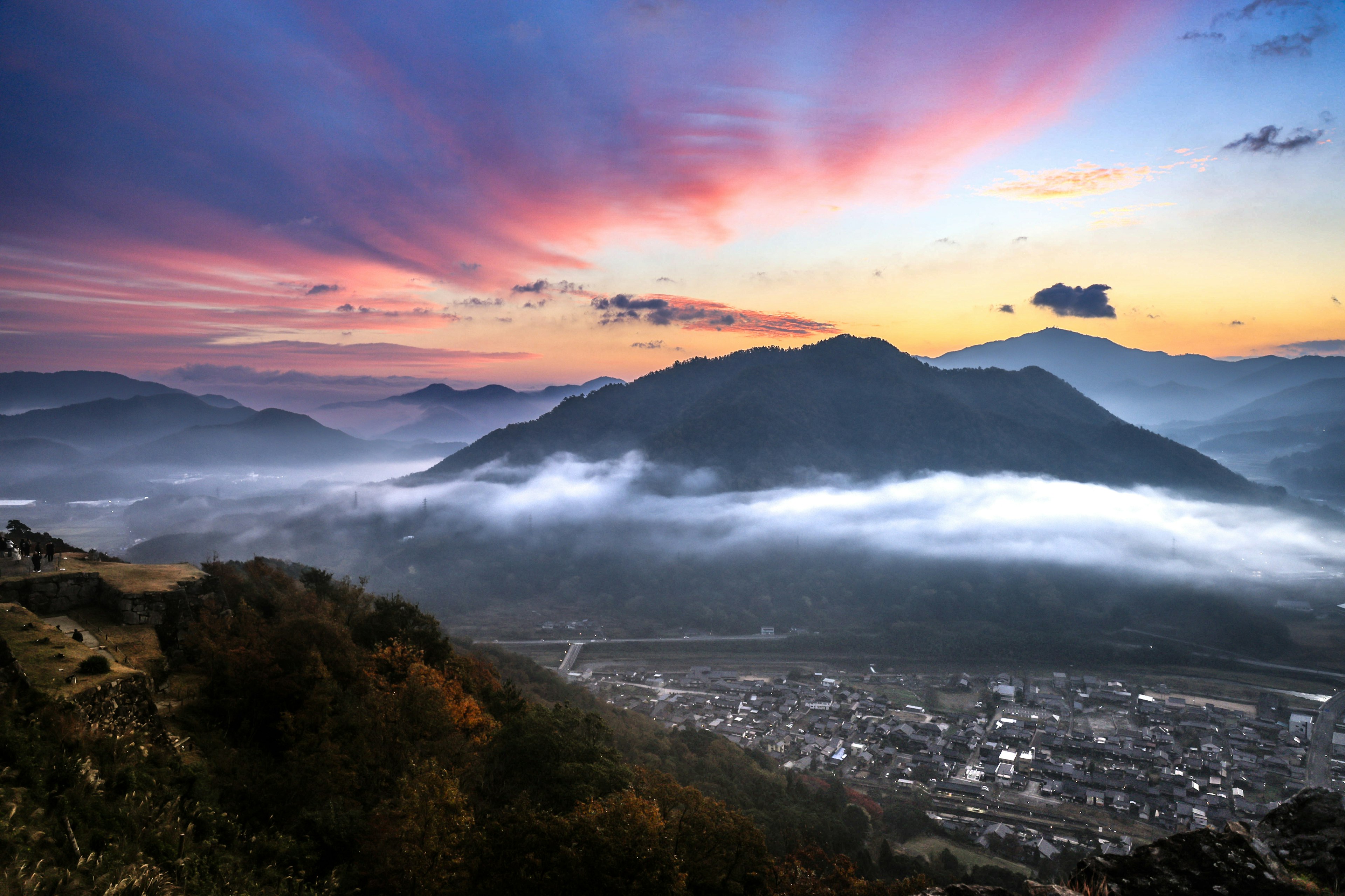 Paysage de coucher de soleil spectaculaire avec montagnes et vallée brumeuse