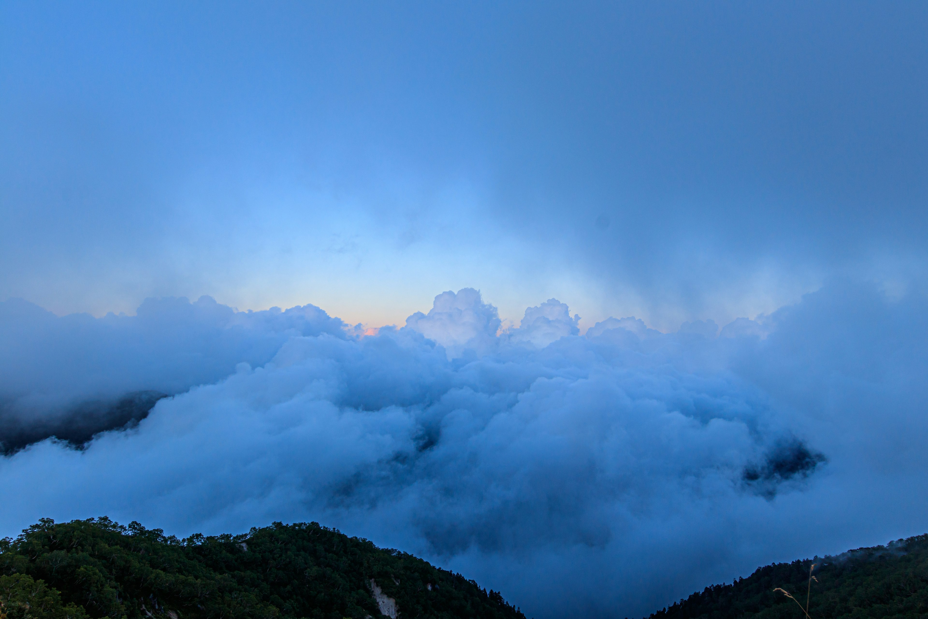 青い空と雲に覆われた山の景色