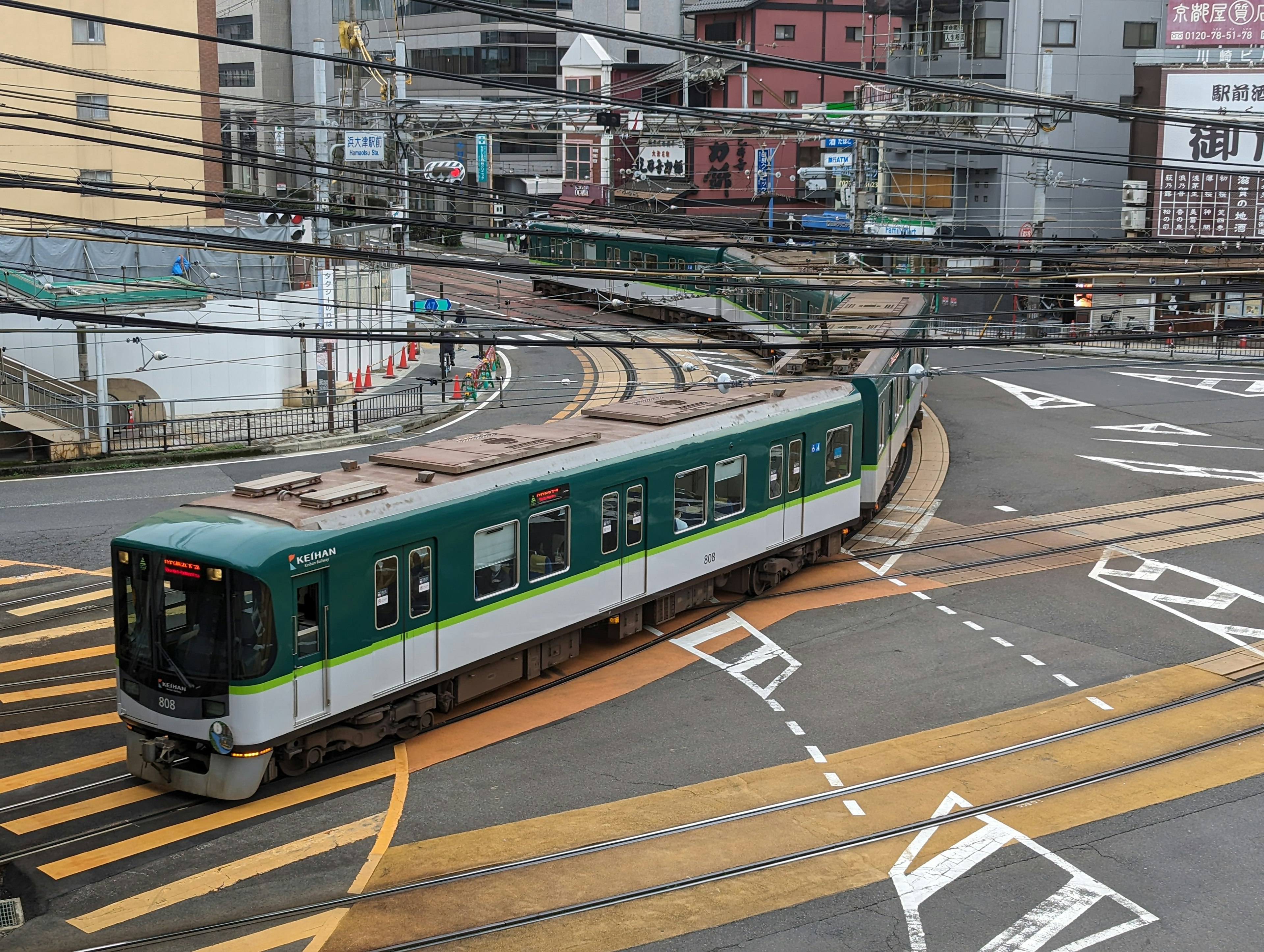 Tren verde girando en un paisaje urbano