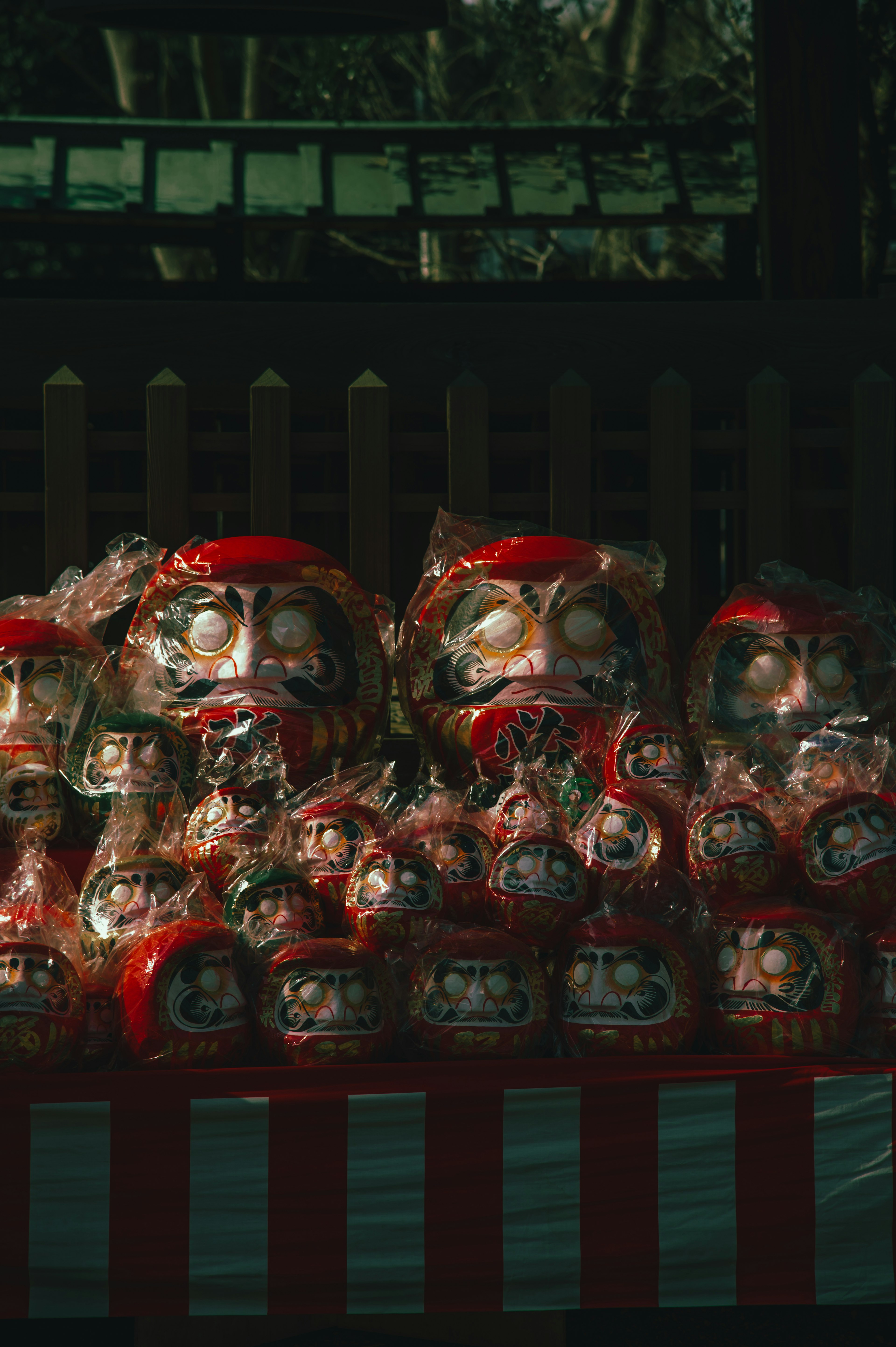 A collection of red daruma dolls displayed in a traditional setting