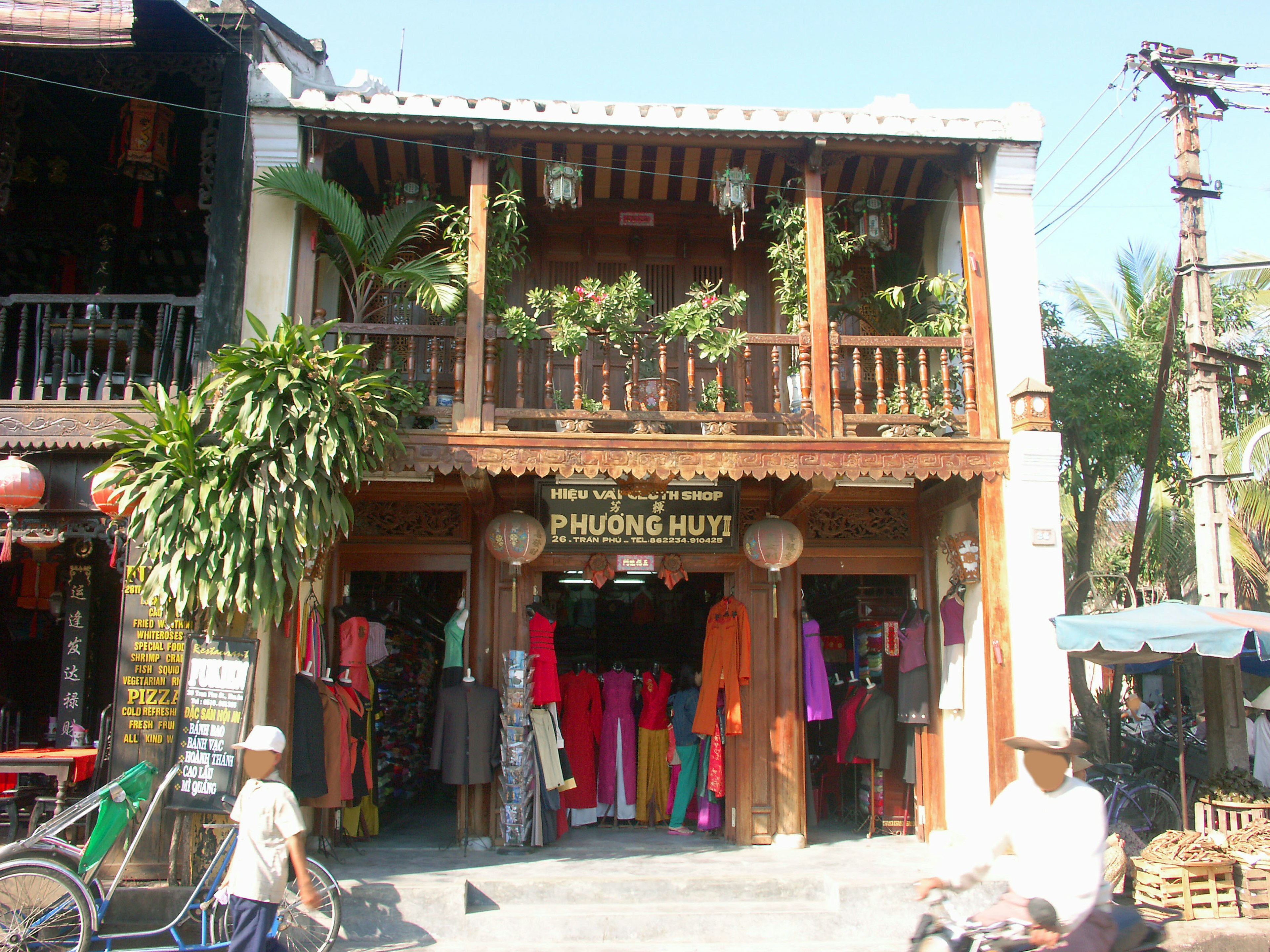 Façade de magasin en bois traditionnel affichant des vêtements colorés