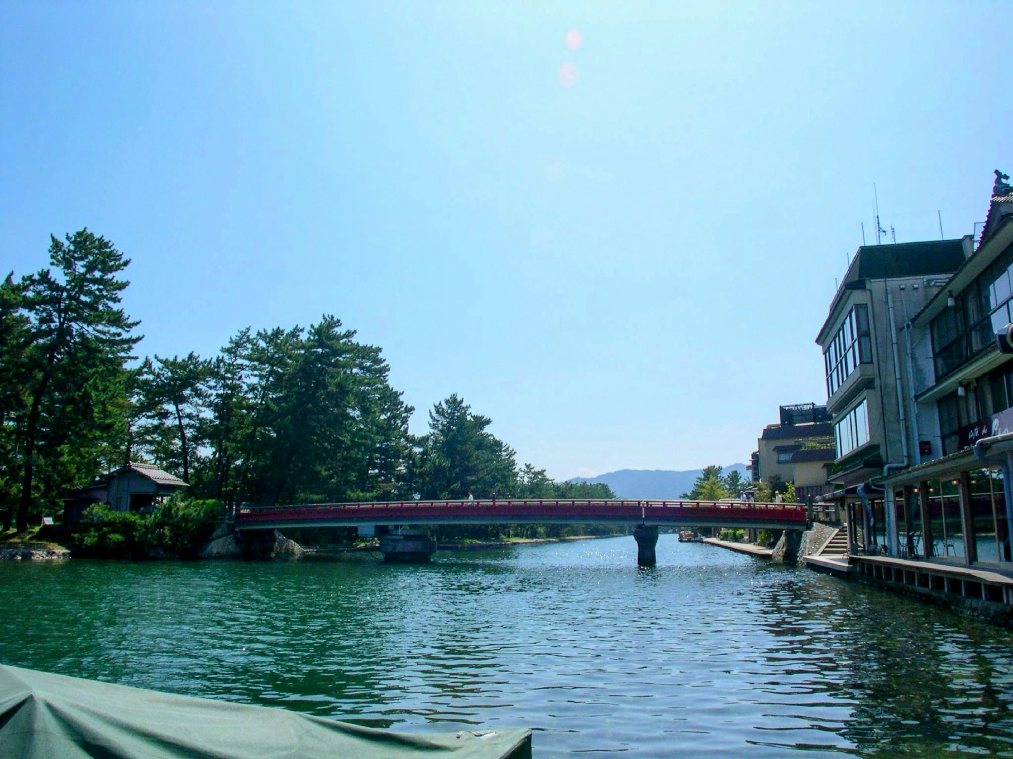 Vista panoramica di un fiume con un ponte rosso sotto un cielo blu