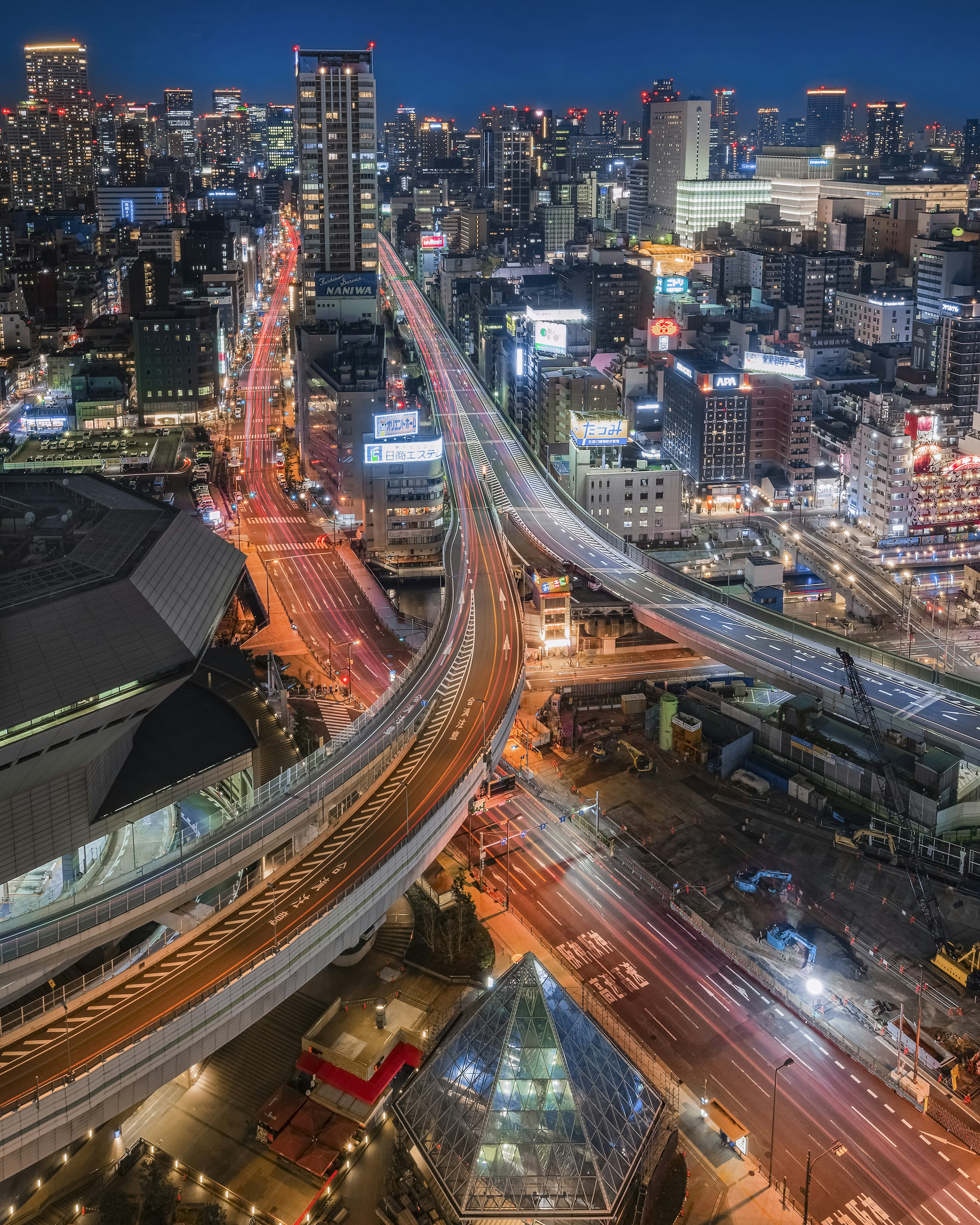 ทิวทัศน์เมืองยามค่ำคืน สะพานและถนนที่ตัดกัน อาคารสมัยใหม่ในพื้นหลัง