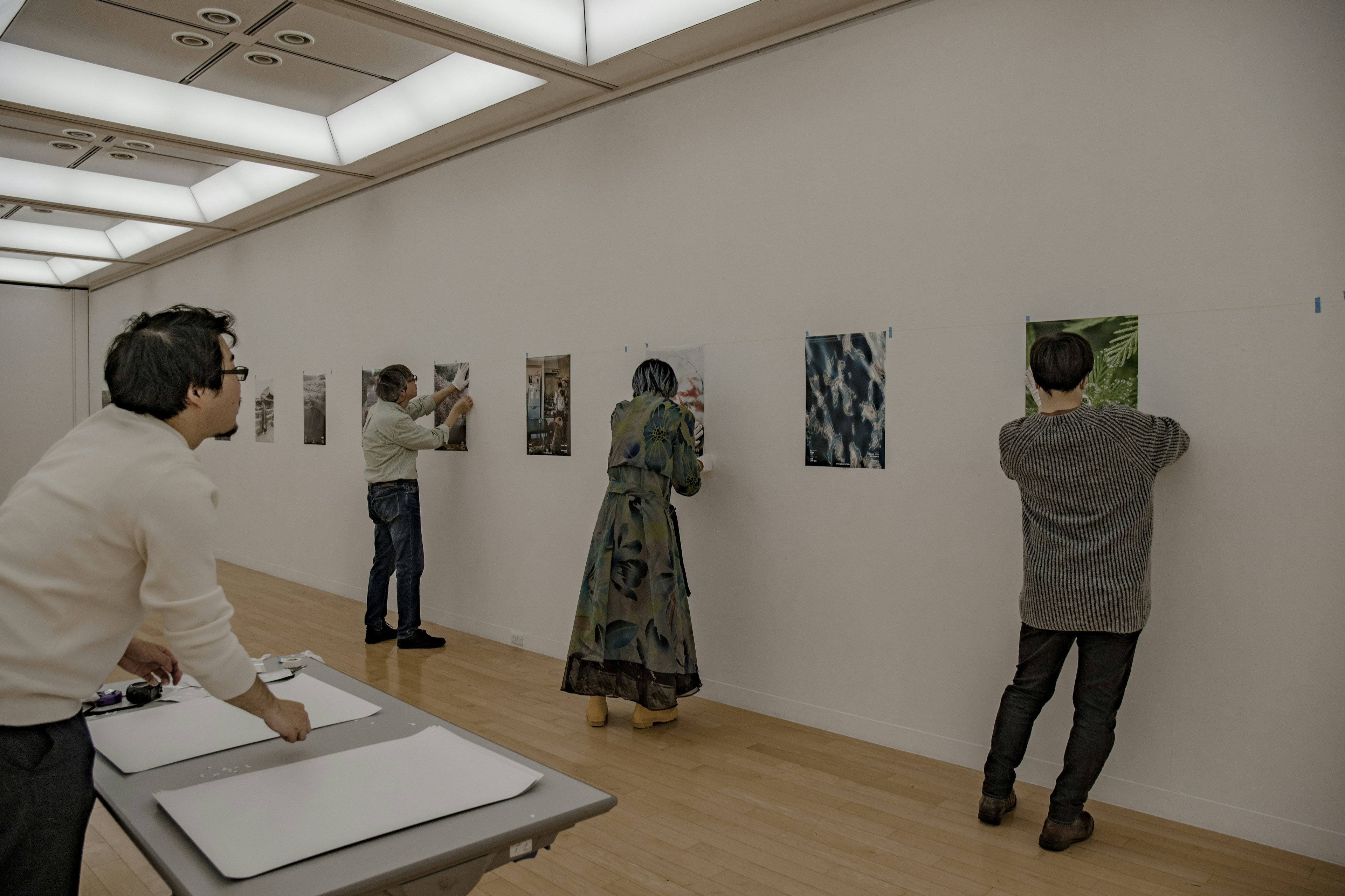 アートギャラリーで作品を鑑賞する人々の後ろ姿 様々な絵が展示されている