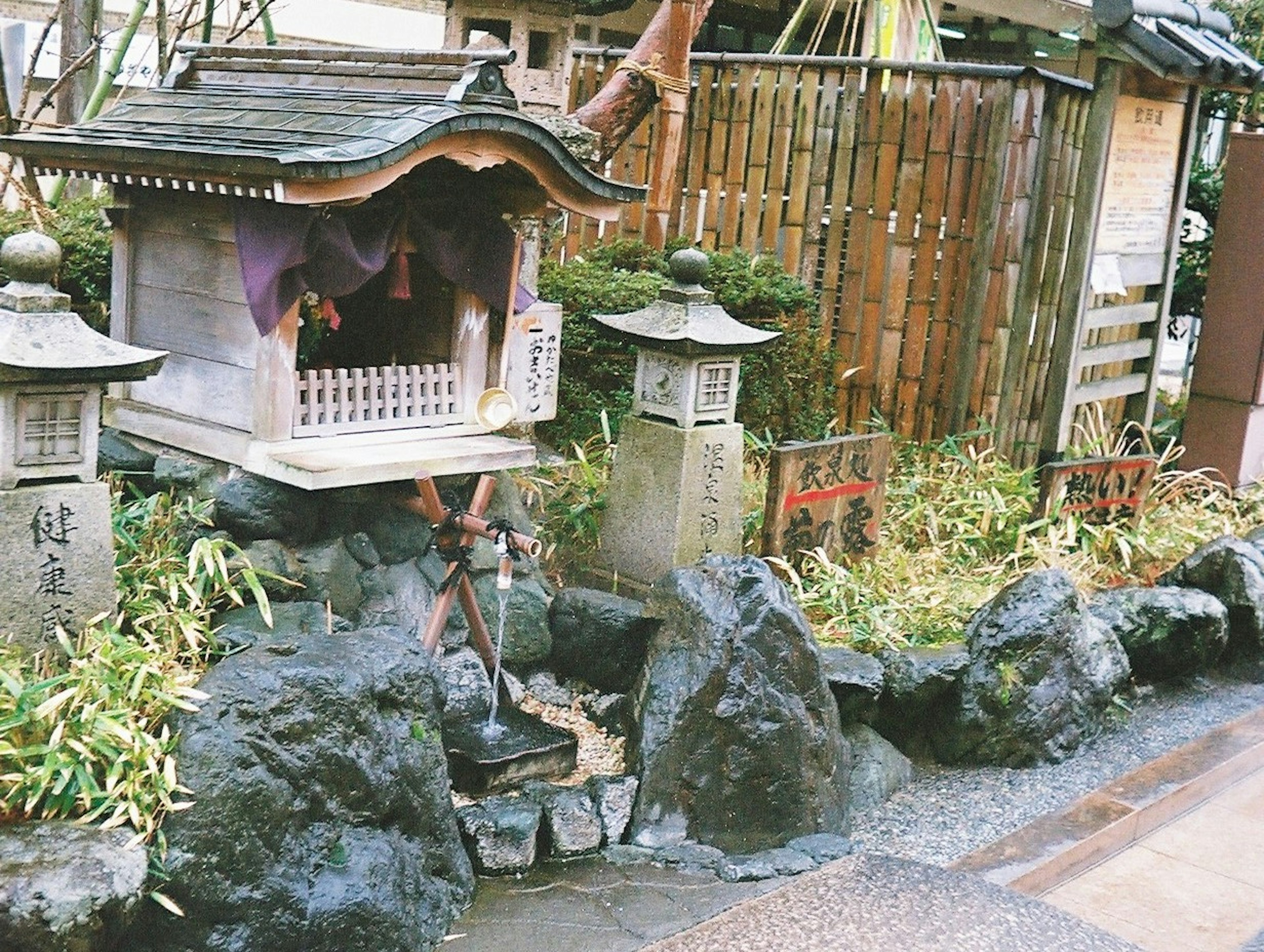 日本の伝統的な神社の境内にある小さな社と石の装飾