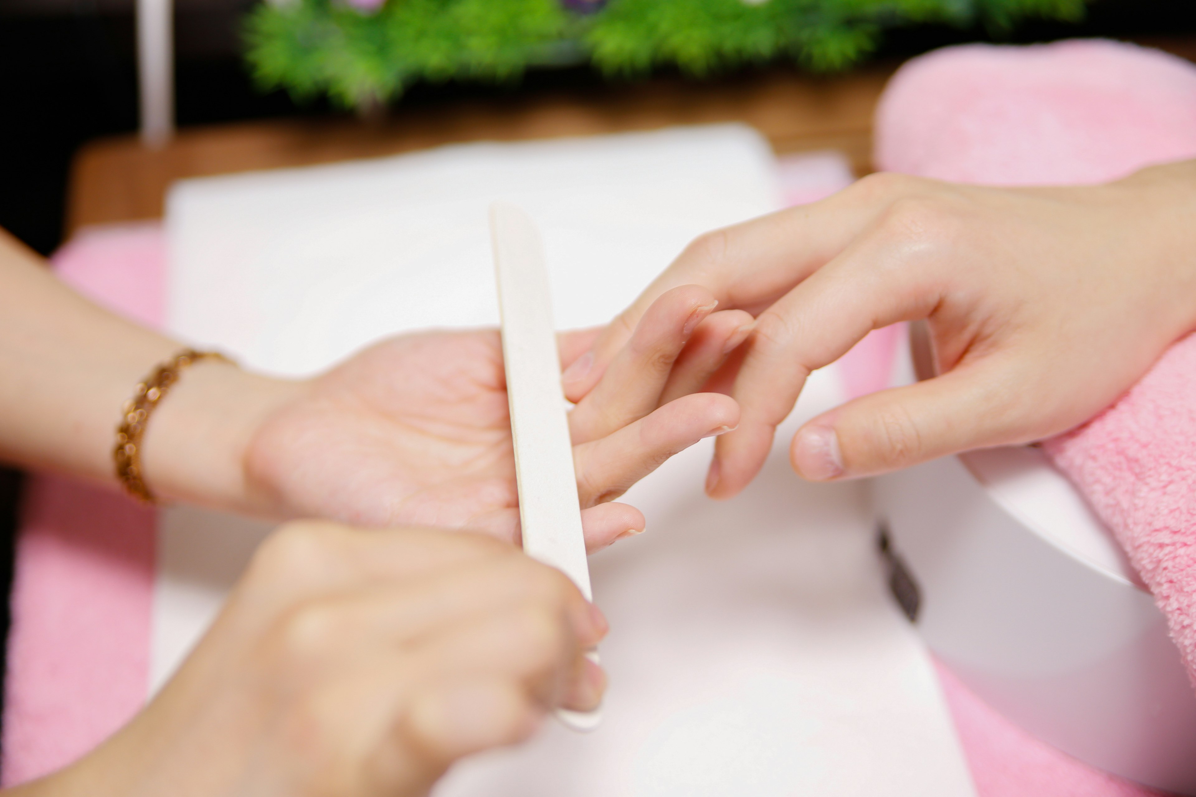 Hands receiving nail care with a file