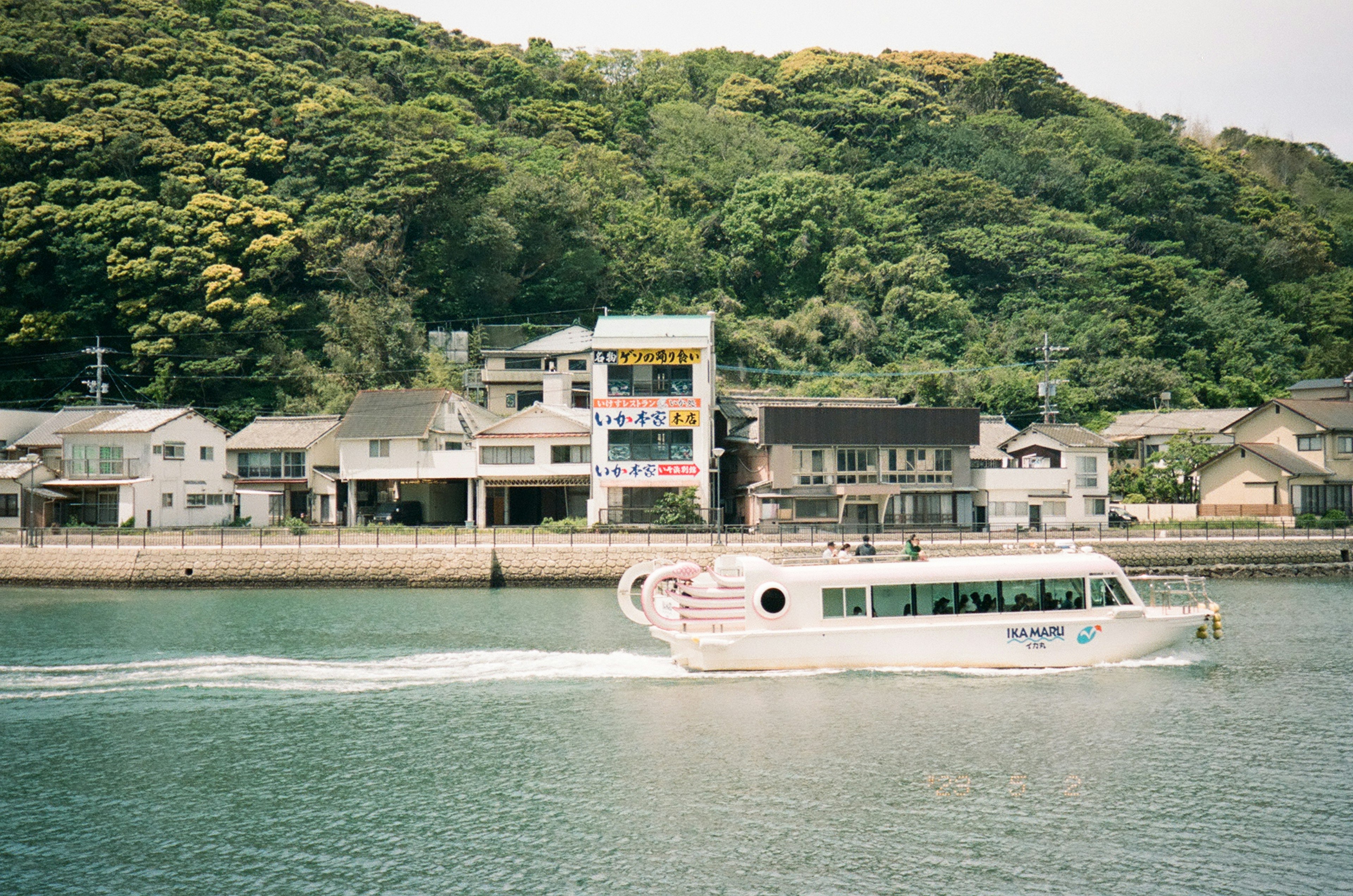 Sightseeing boat moving on the river with colorful buildings in the background