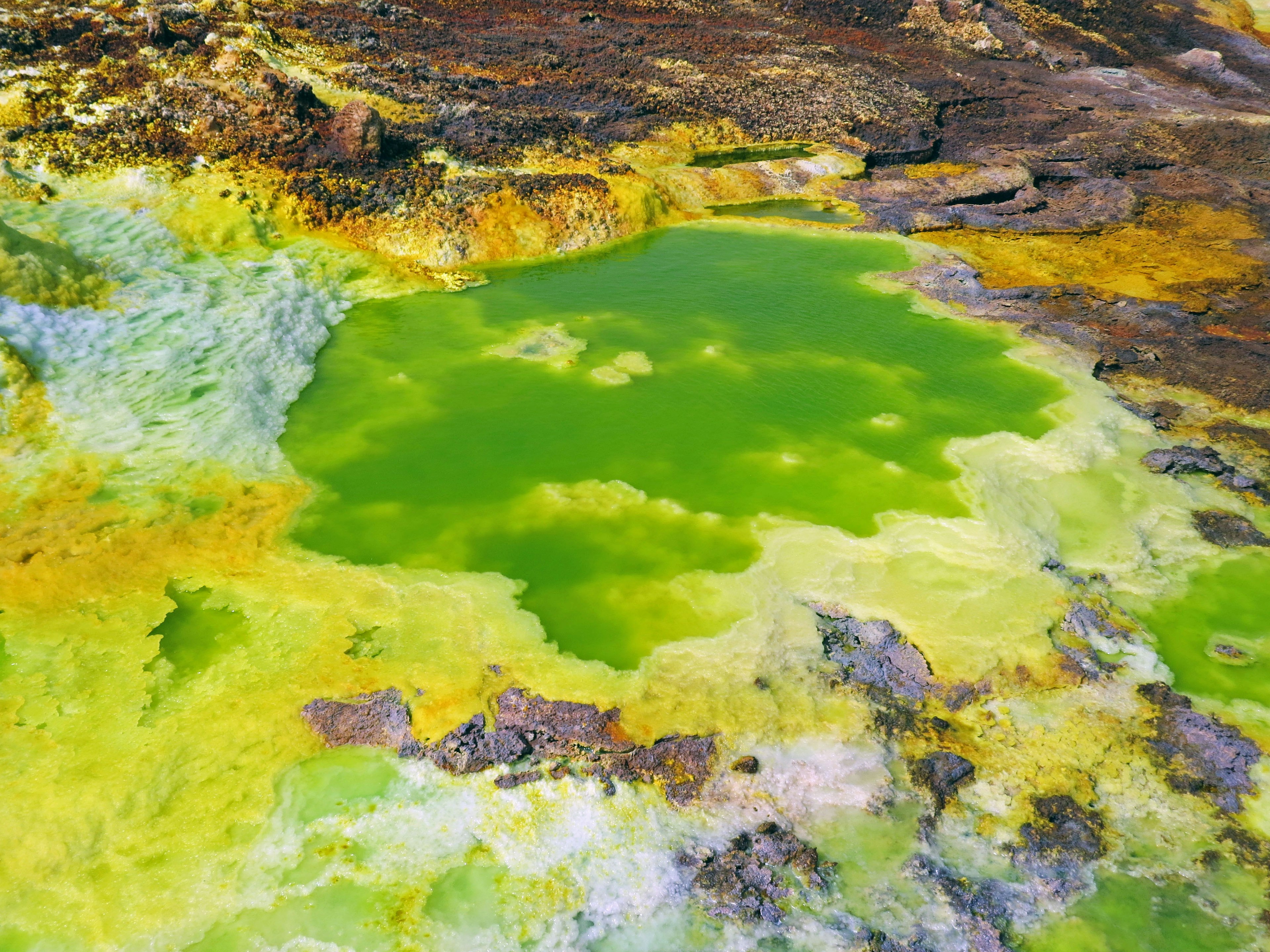 Paisaje geotérmico colorido con un estanque verde