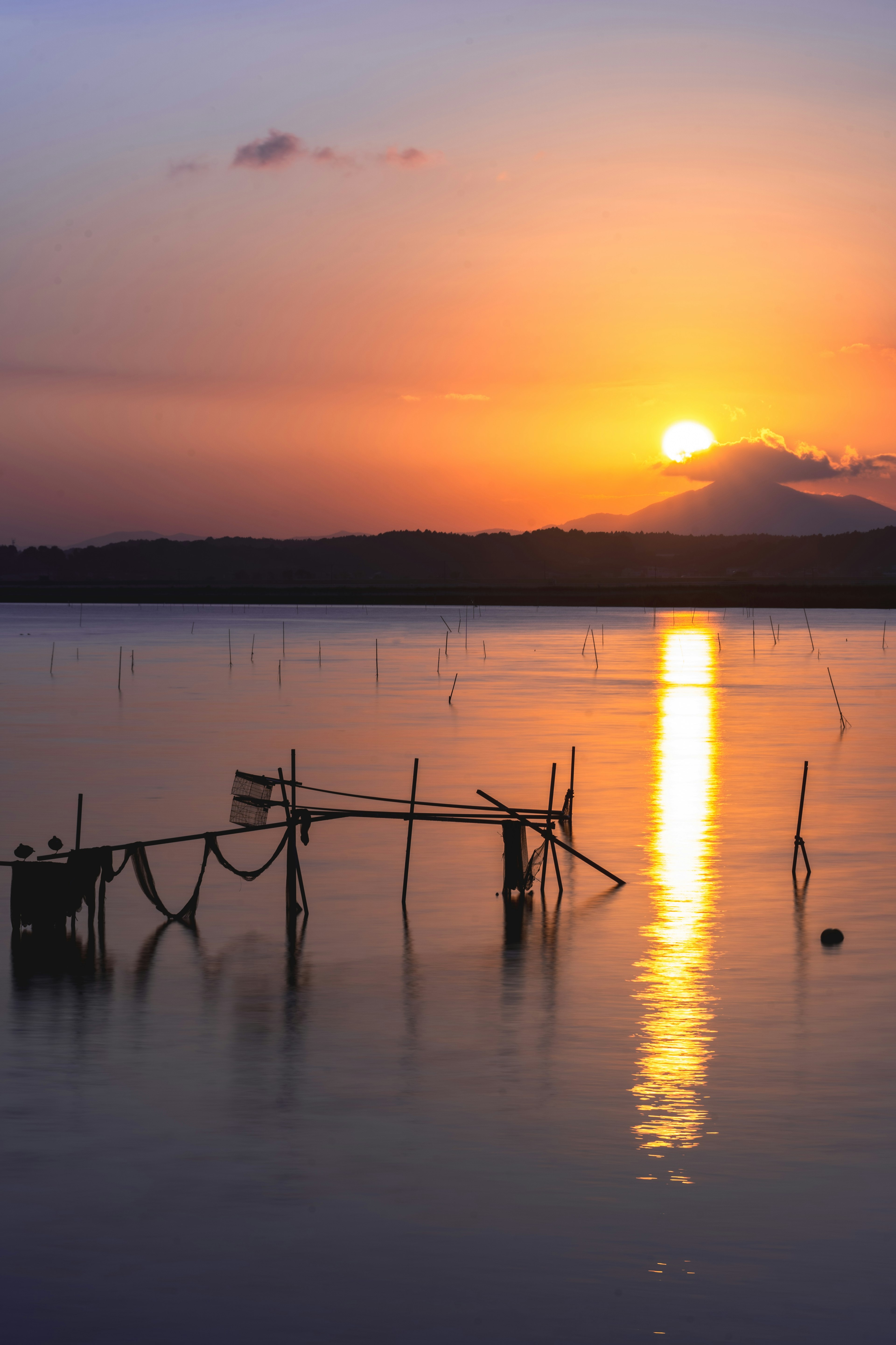 美しい夕焼けと水面の反射が映える静かな湖の風景