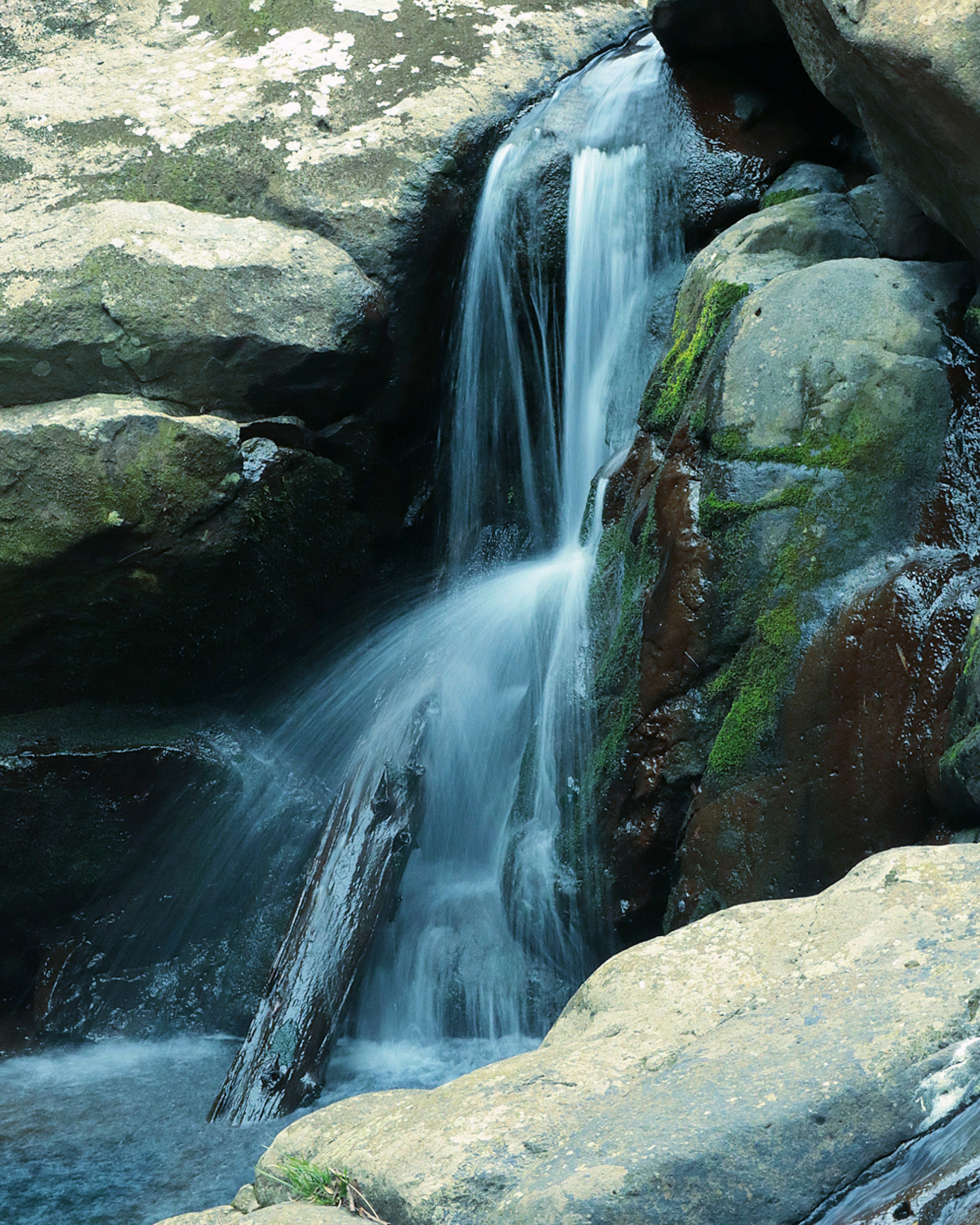 Waterfall cascading over rocks with smooth water flow