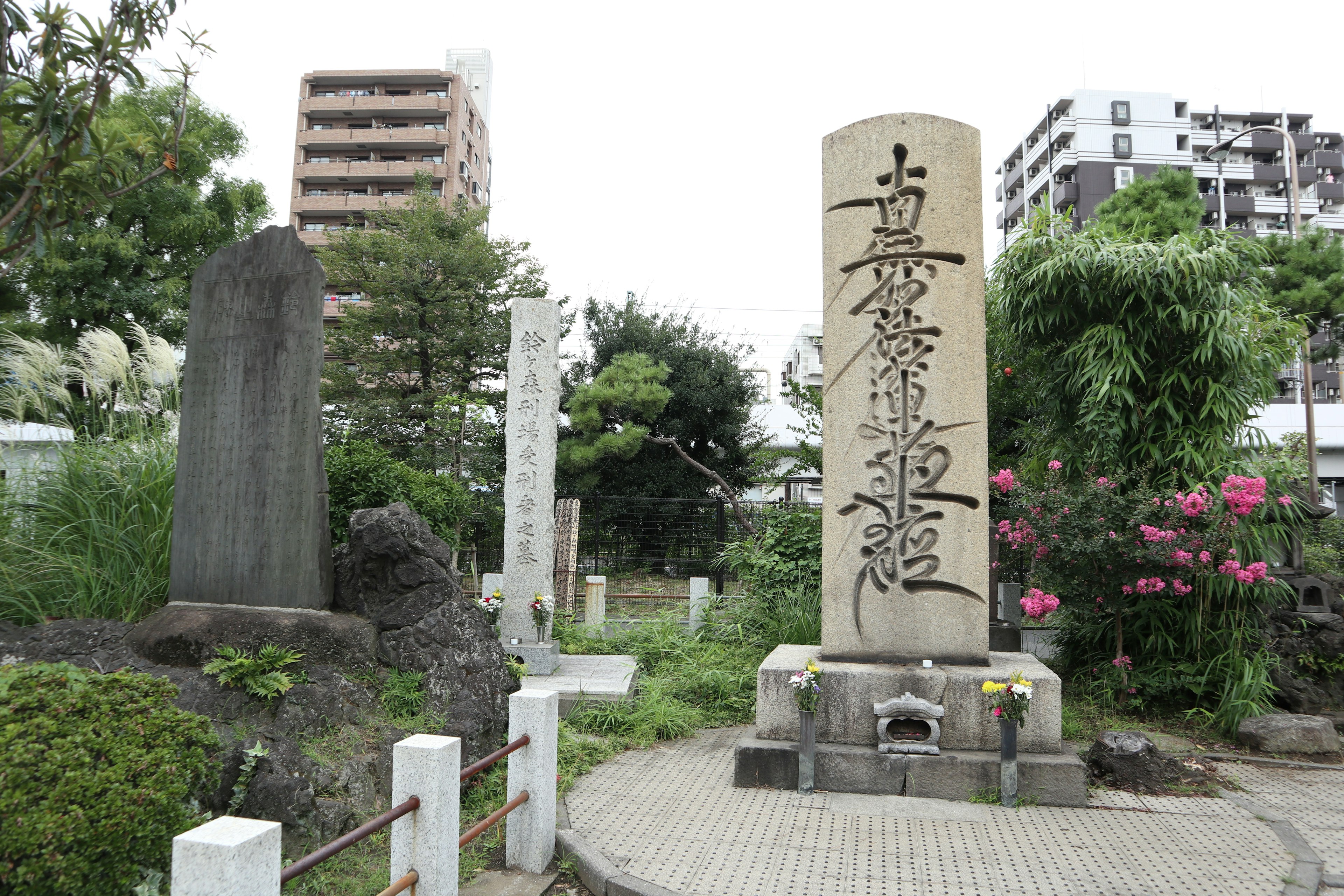 Stone monument in a park surrounded by green plants