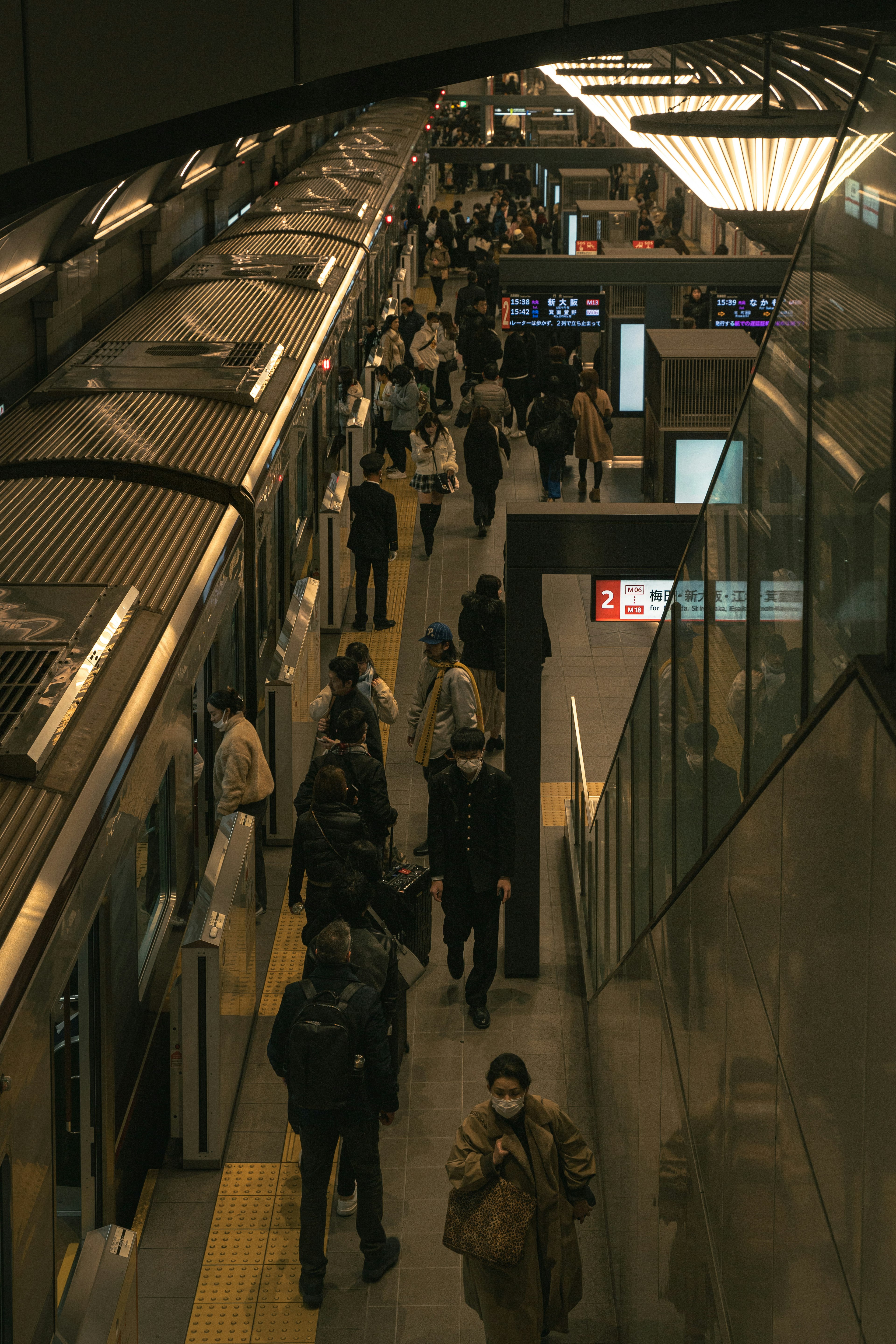 Plataforma de estación de tren concurrida con personas y trenes