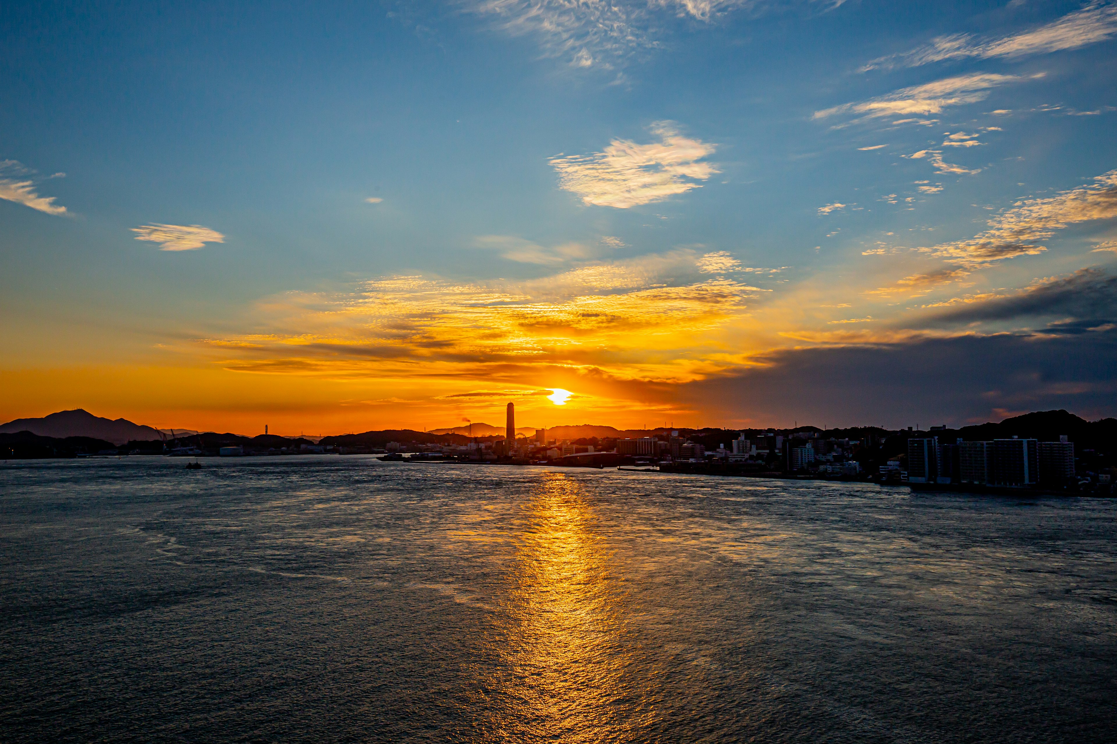 Schöner Sonnenuntergang über dem Meer mit blauem Himmel und orangefarbenen Wolken