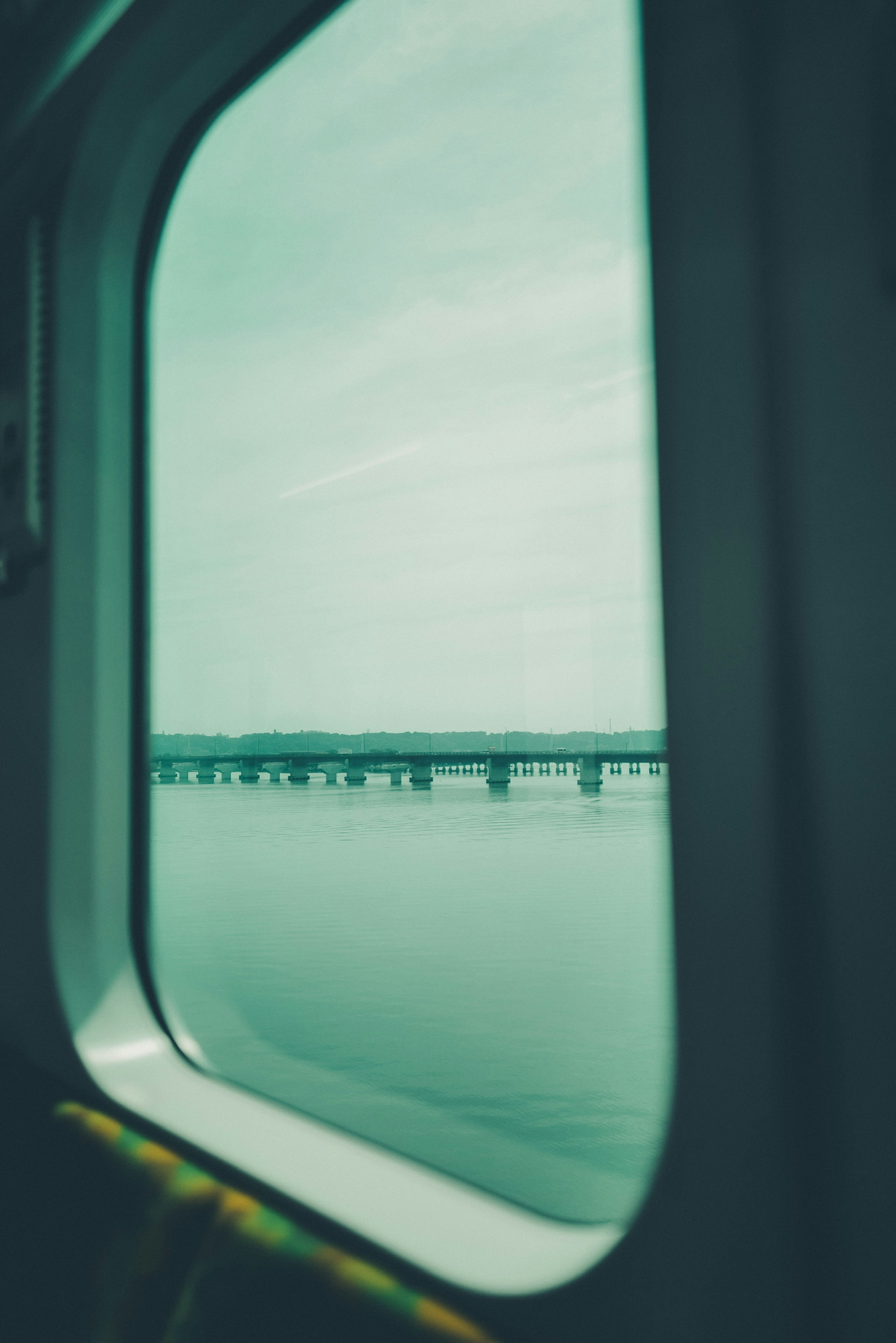 View of water and bridge through a train window