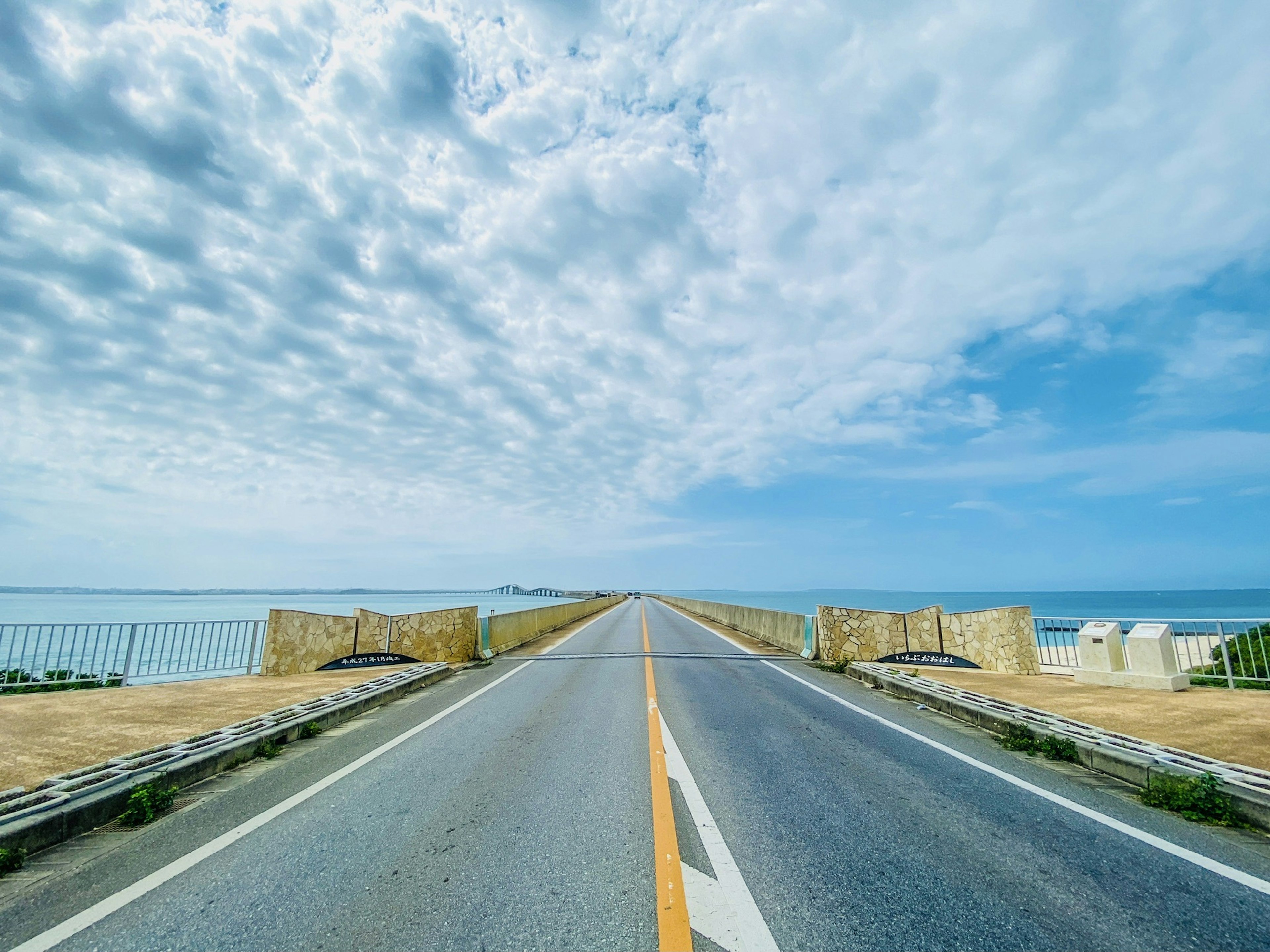 Route menant vers l'océan sous un ciel bleu