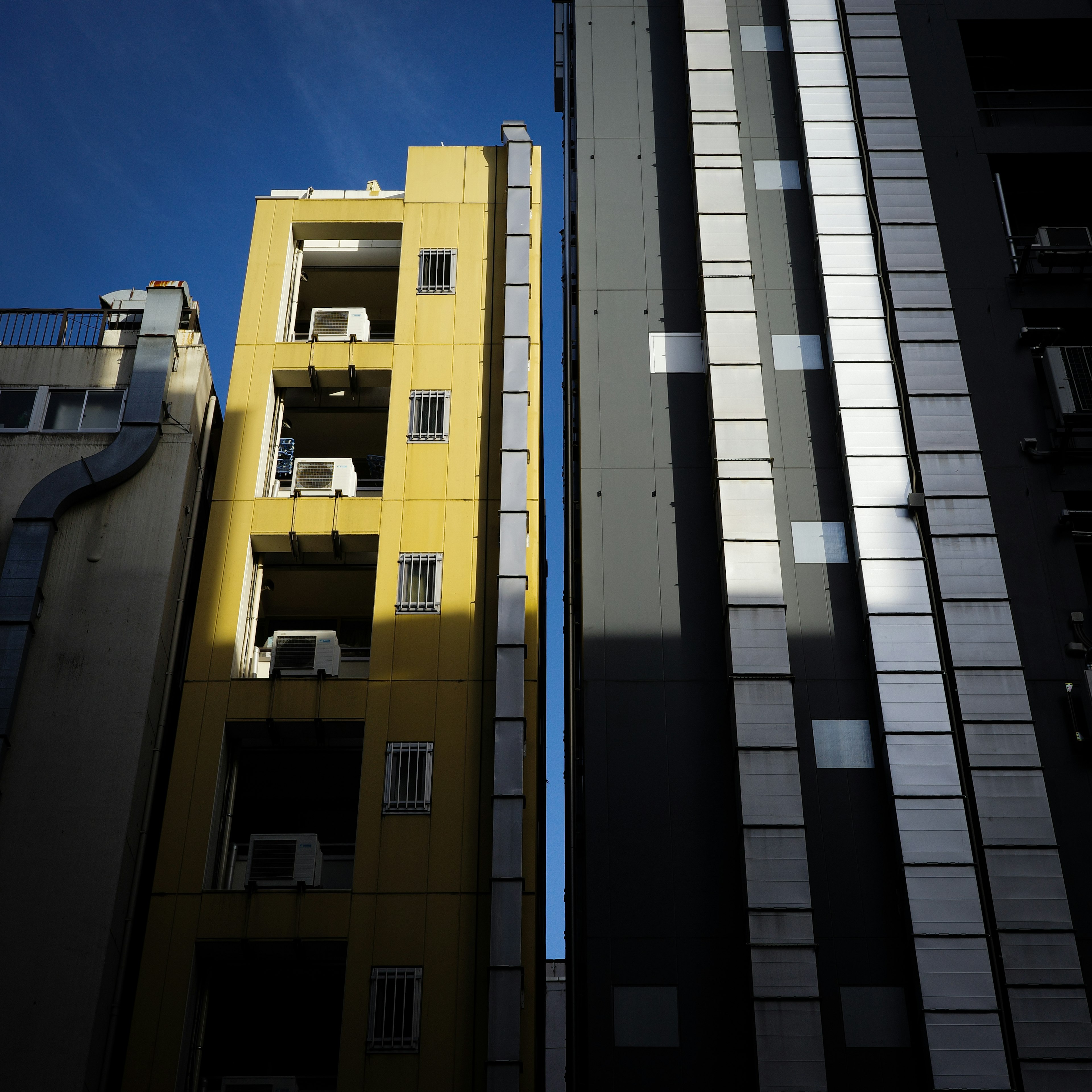 黄色い建物と黒い建物が並ぶ都市の風景