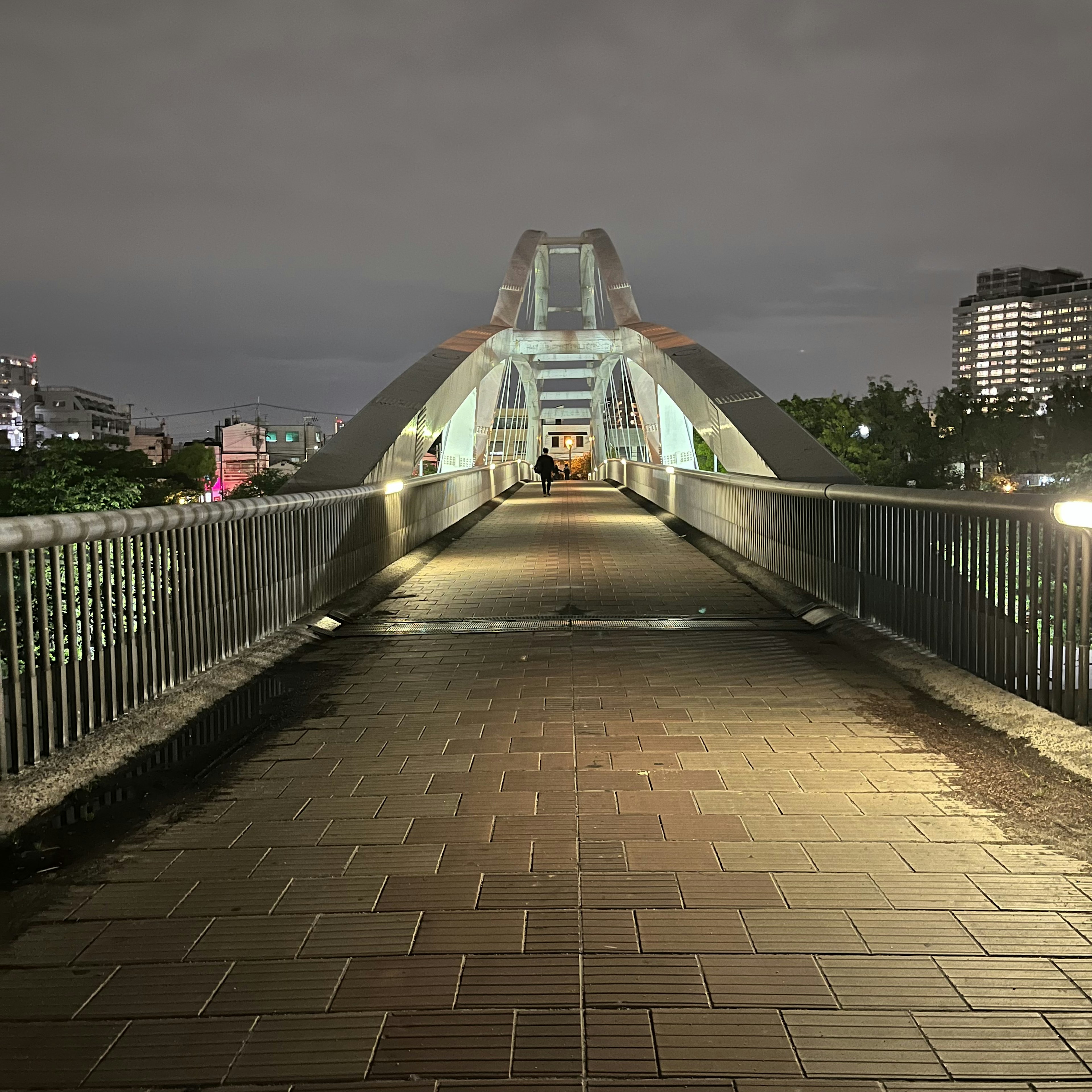 Photo of a modern pedestrian bridge at night in an urban setting