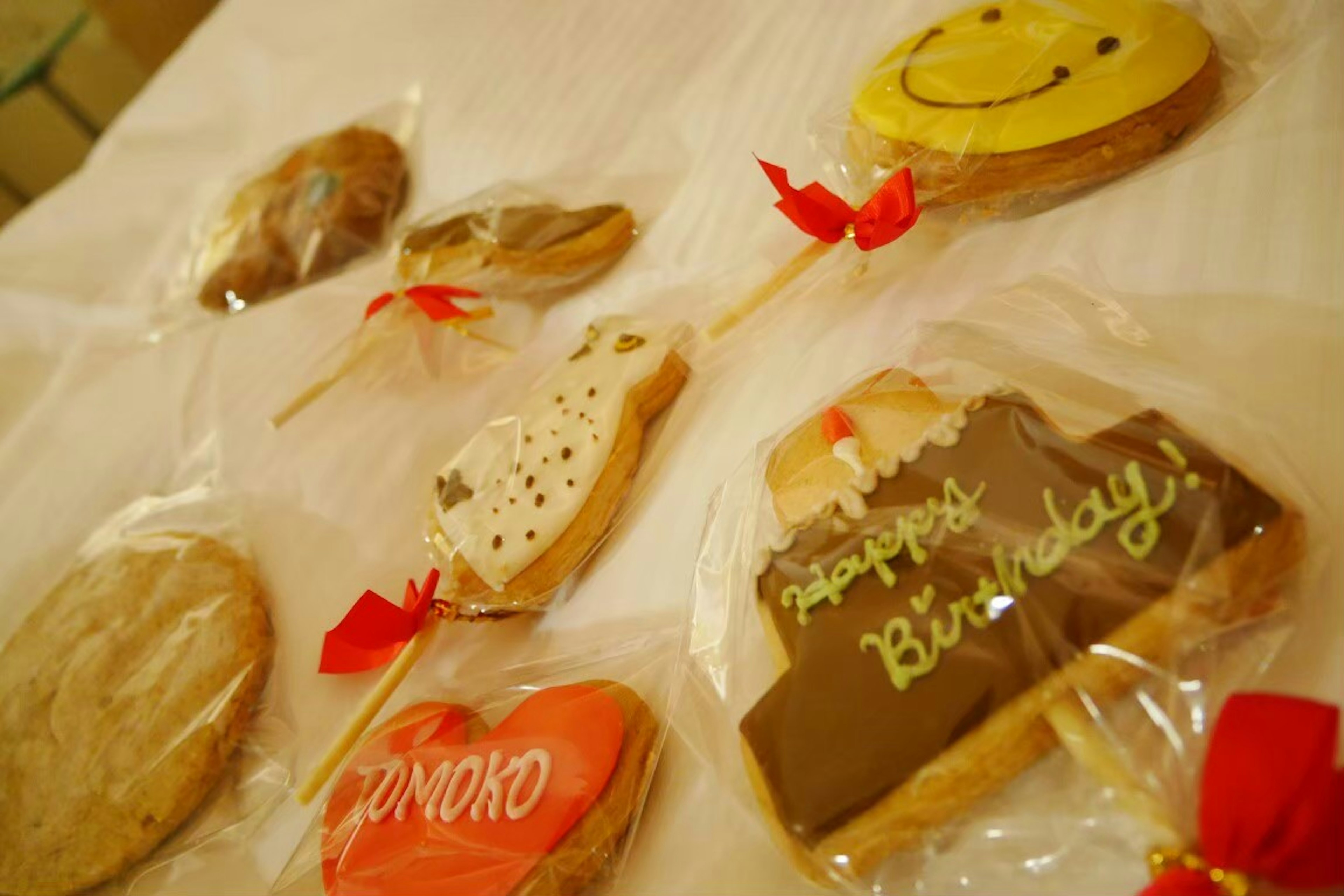 Biscotti colorati con messaggi di compleanno disposti su una superficie