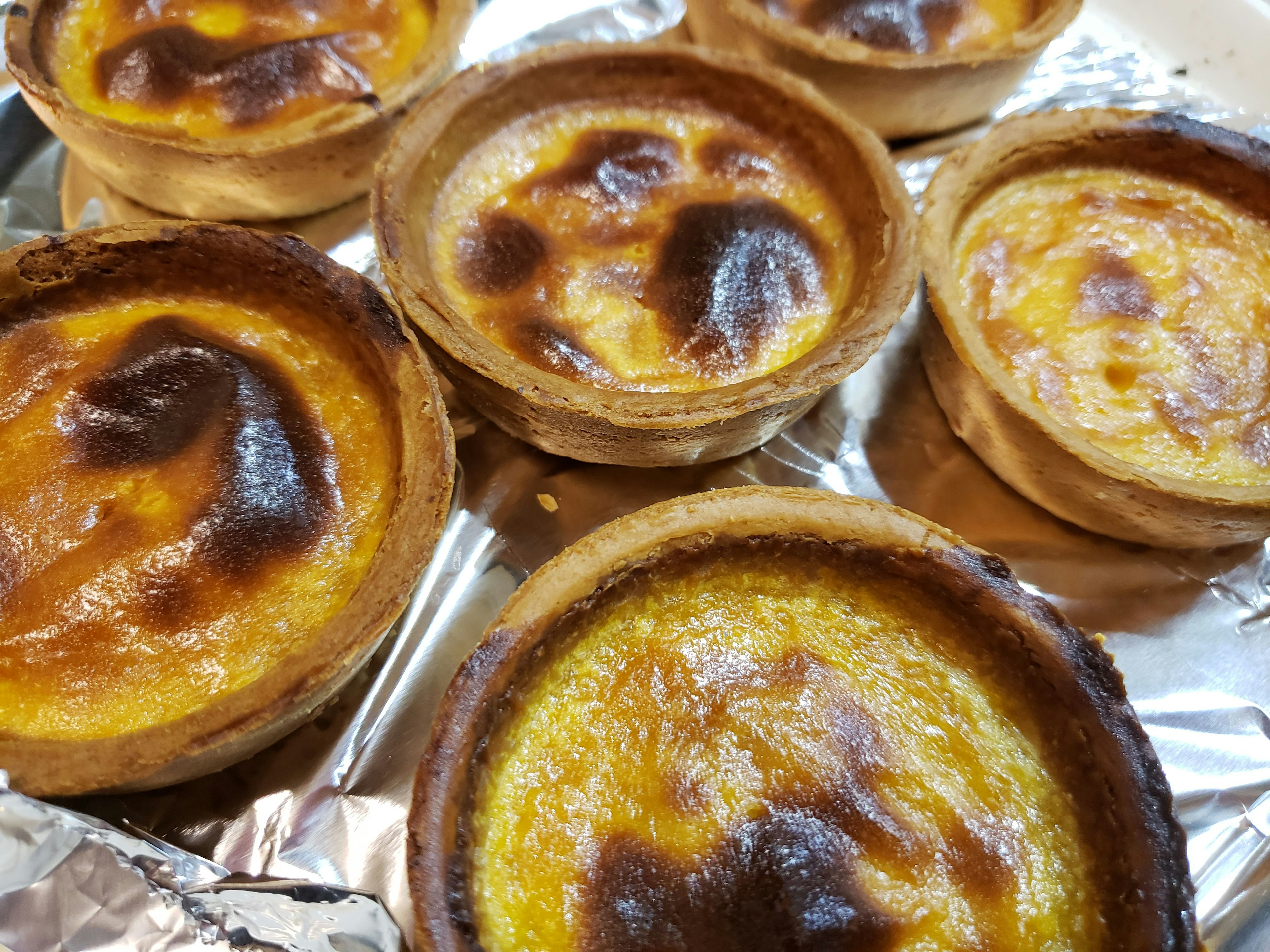 A collection of baked tart desserts with golden brown tops