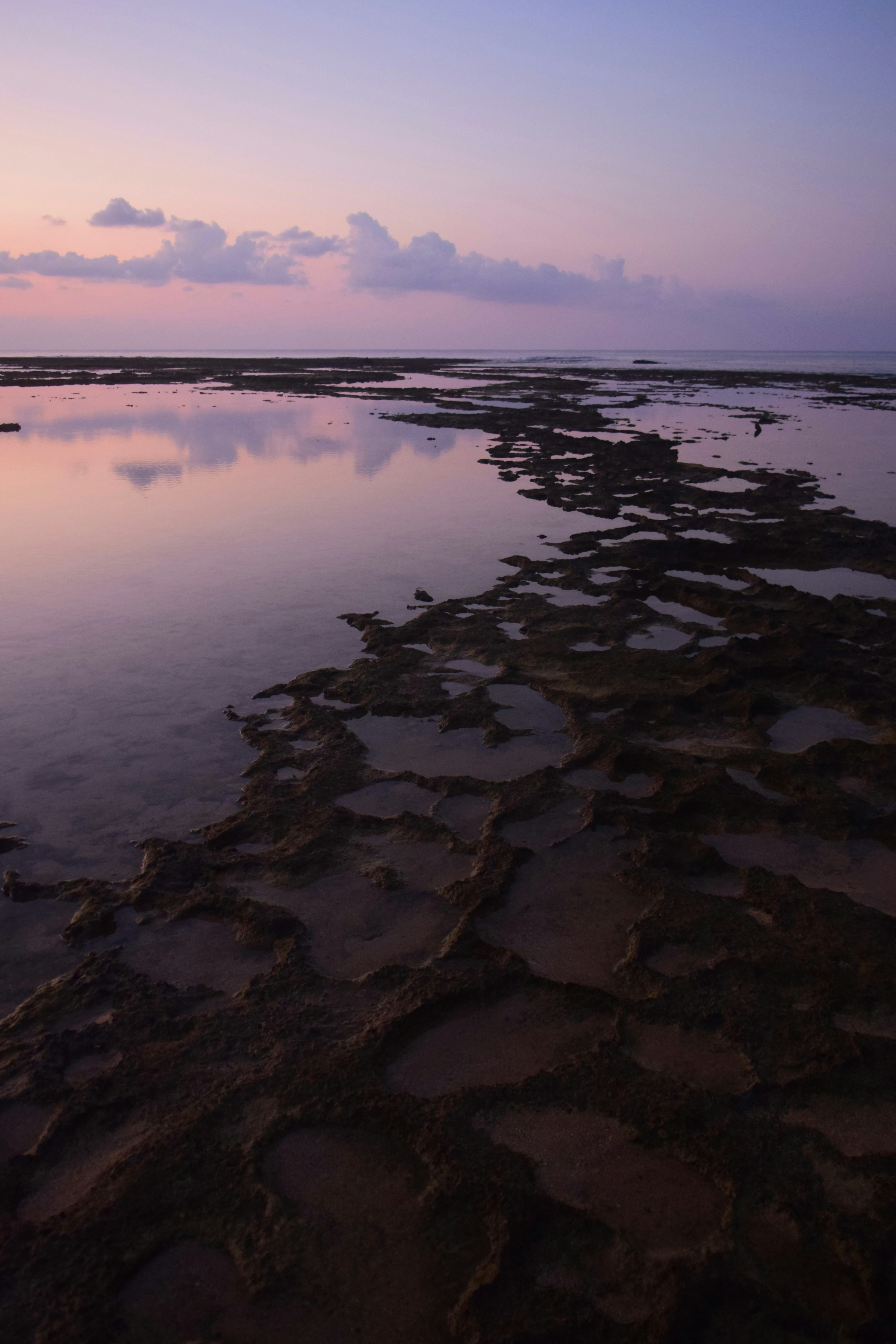 Cielo y nubes al atardecer reflejados en charcas de marea a lo largo de la costa