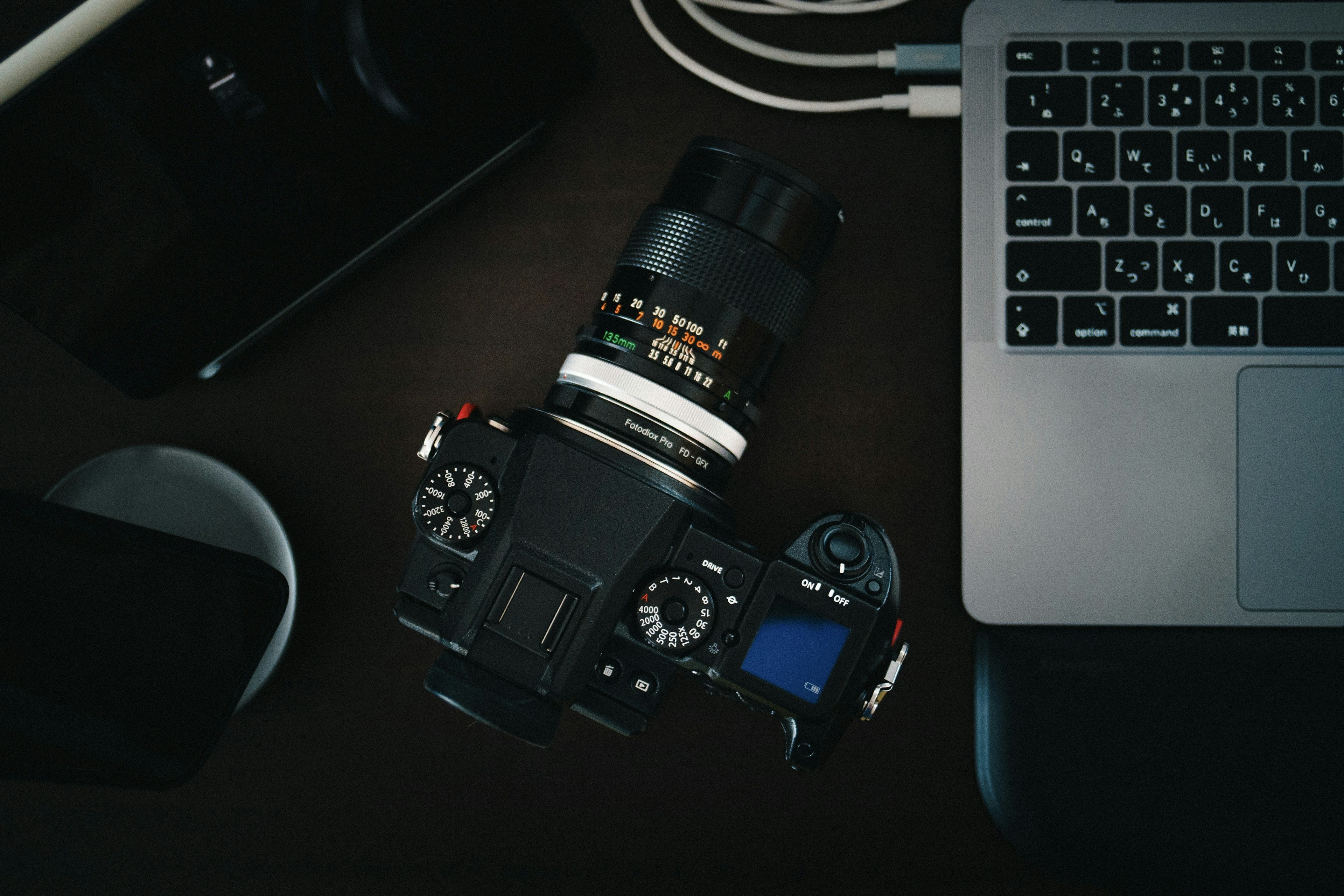 Camera and laptop on a desk scene