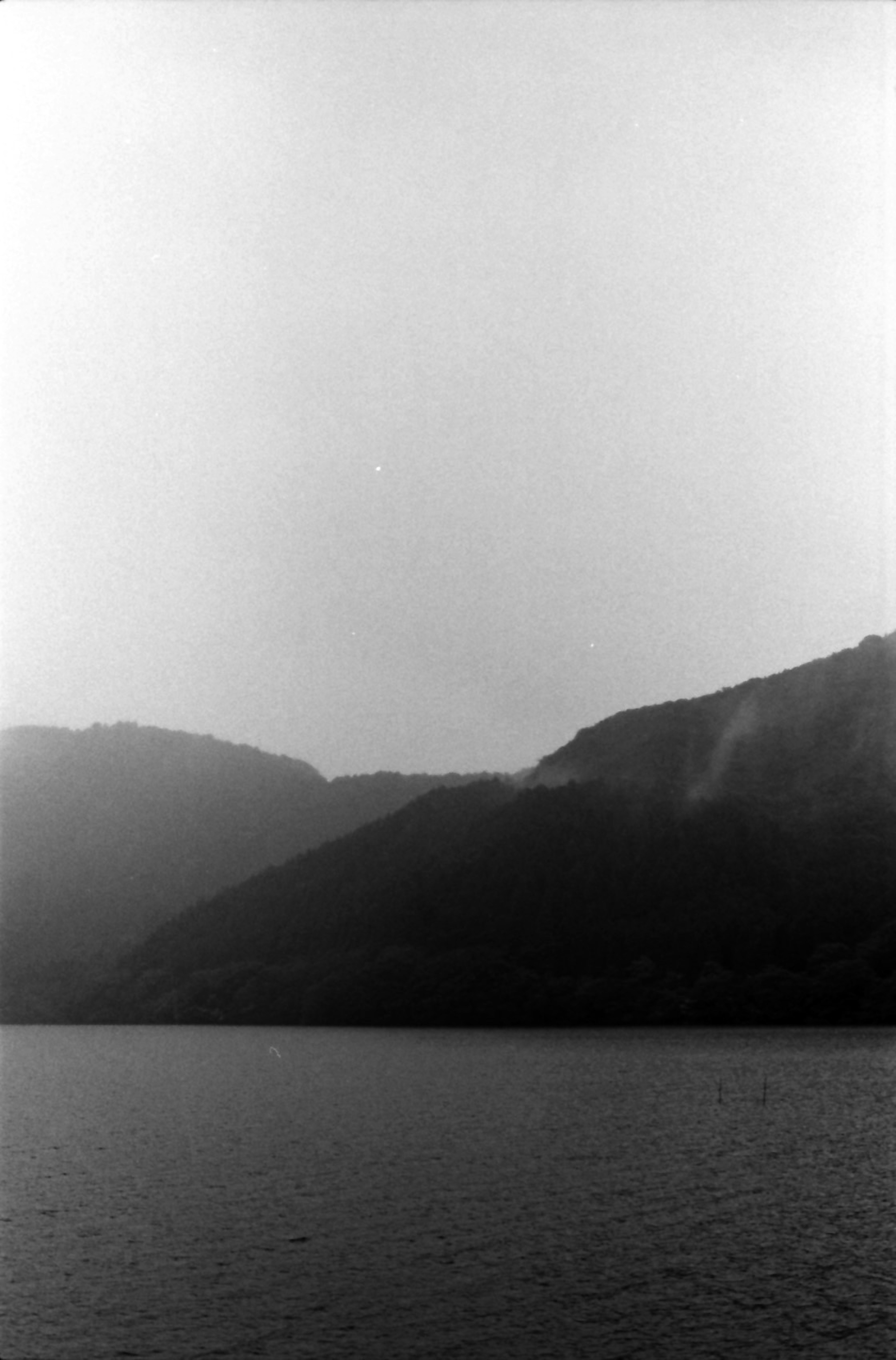 Foto in bianco e nero con montagne e superficie d'acqua