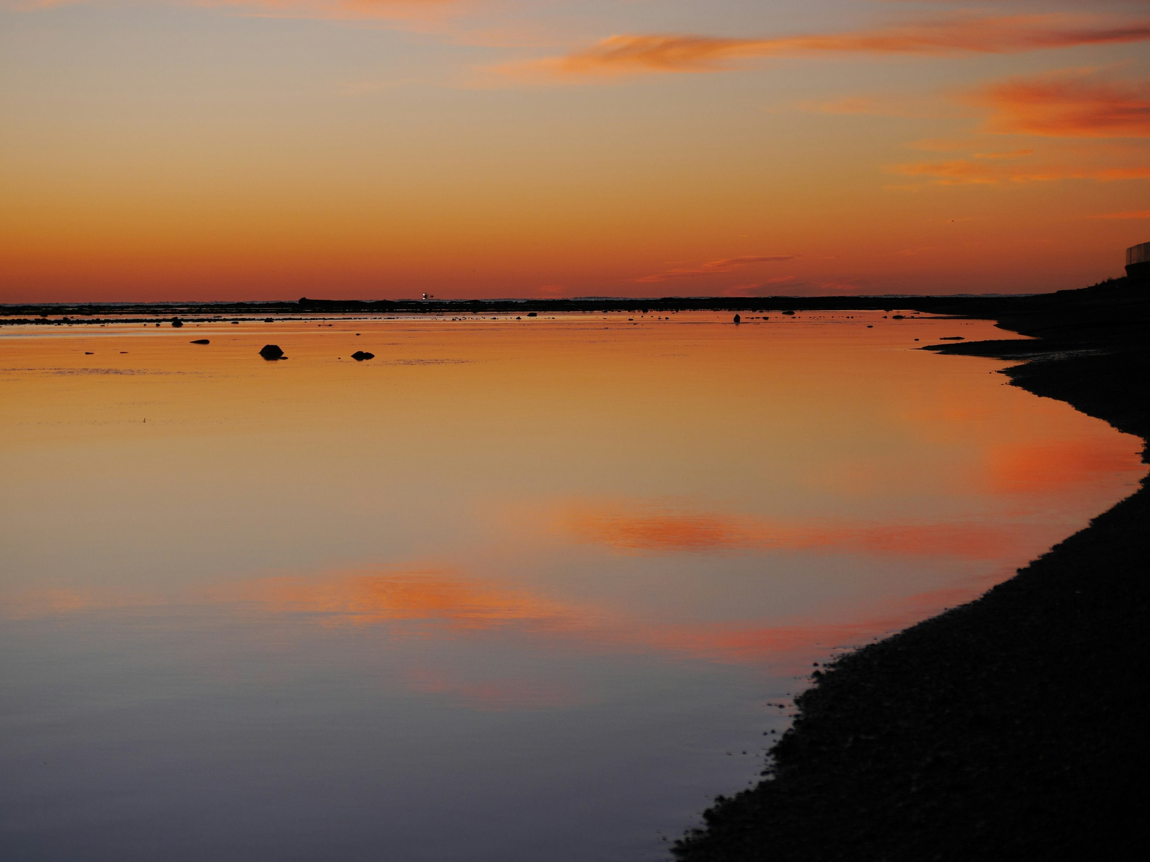 夕焼けの美しい湖の風景オレンジとピンクの空の反射