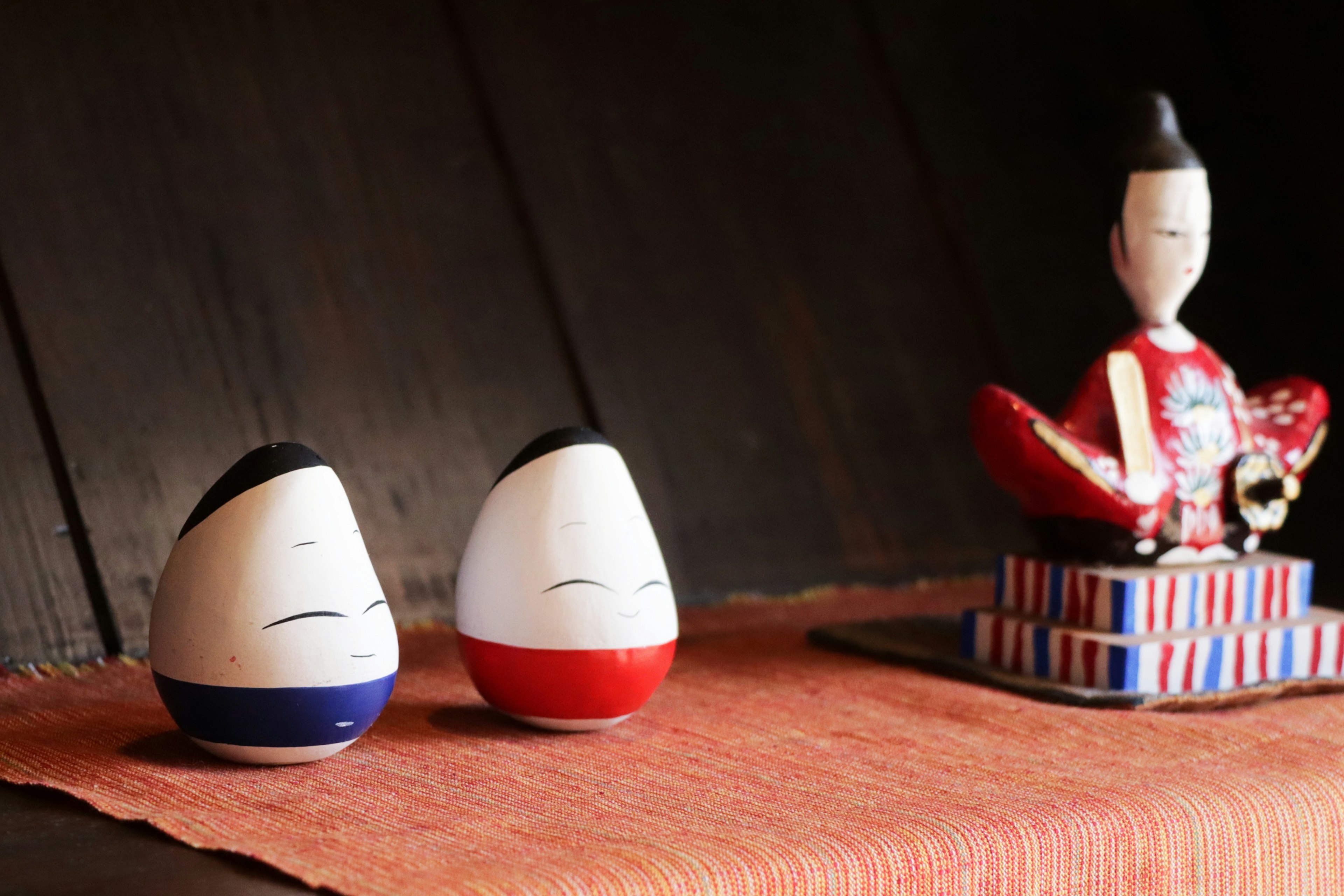 Small red and blue figurines next to a traditional larger figurine