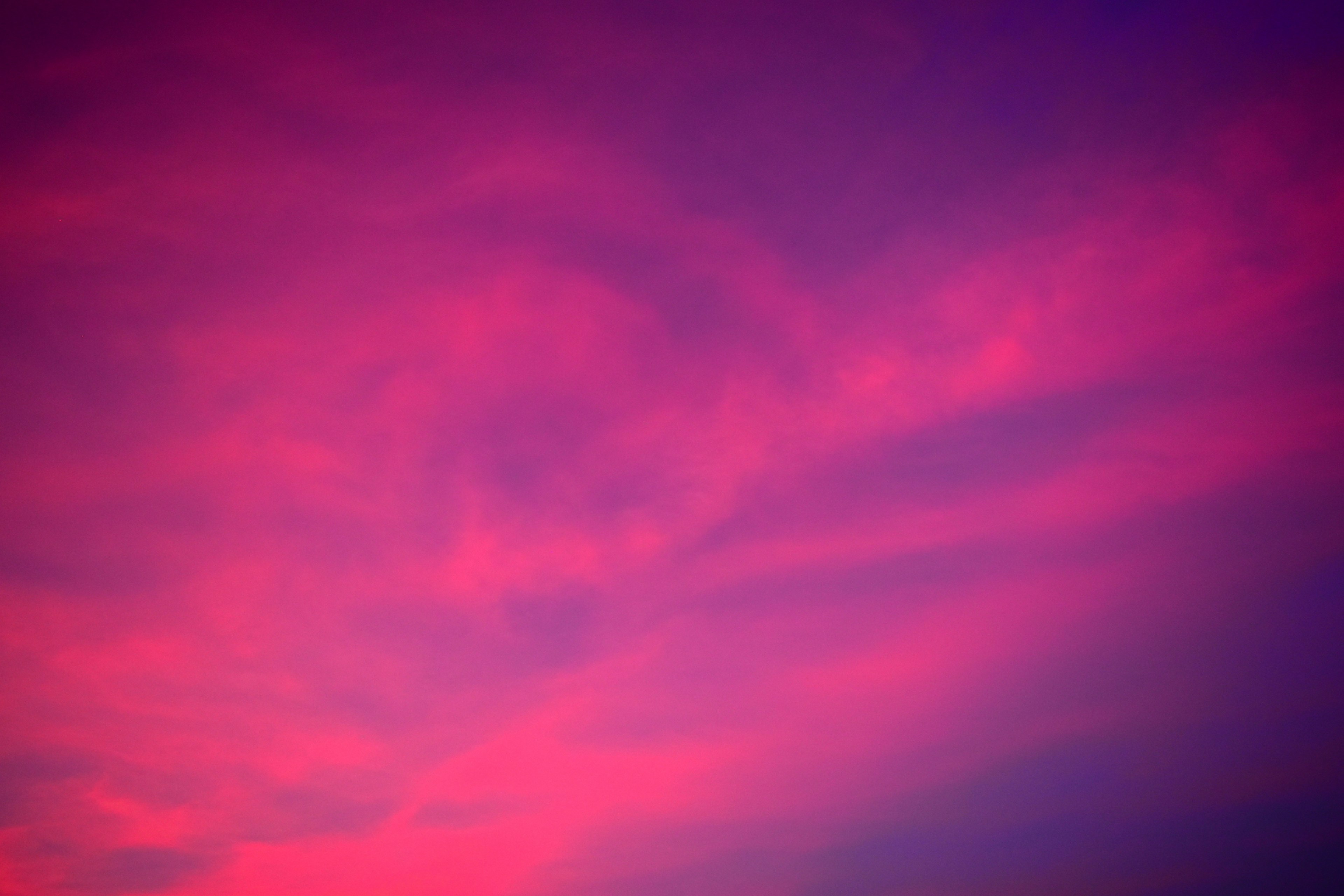 Wolkenmuster in einem lebhaften rosa und lila Himmel