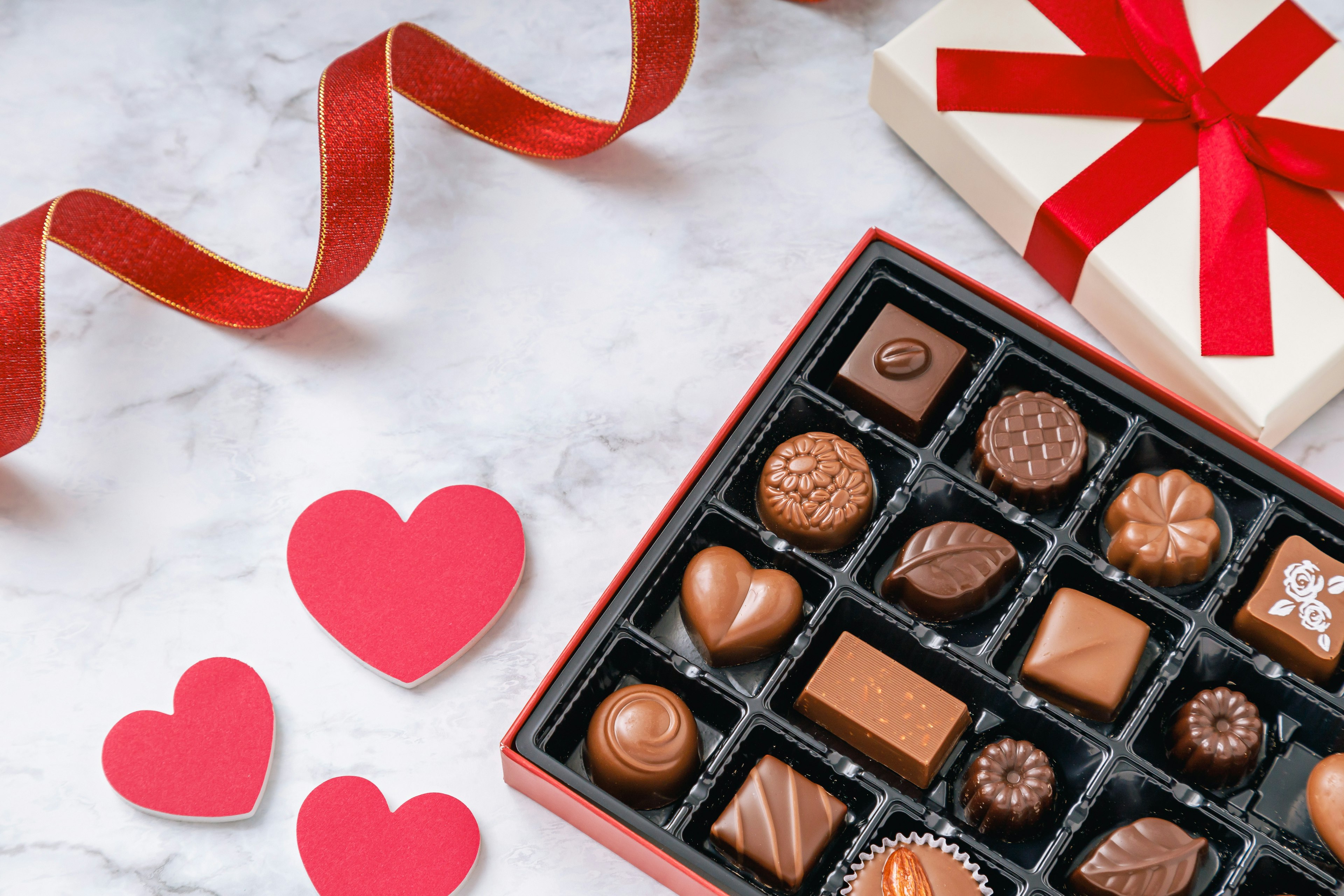 Valentine's Day design featuring a box of chocolates and red heart-shaped decorations