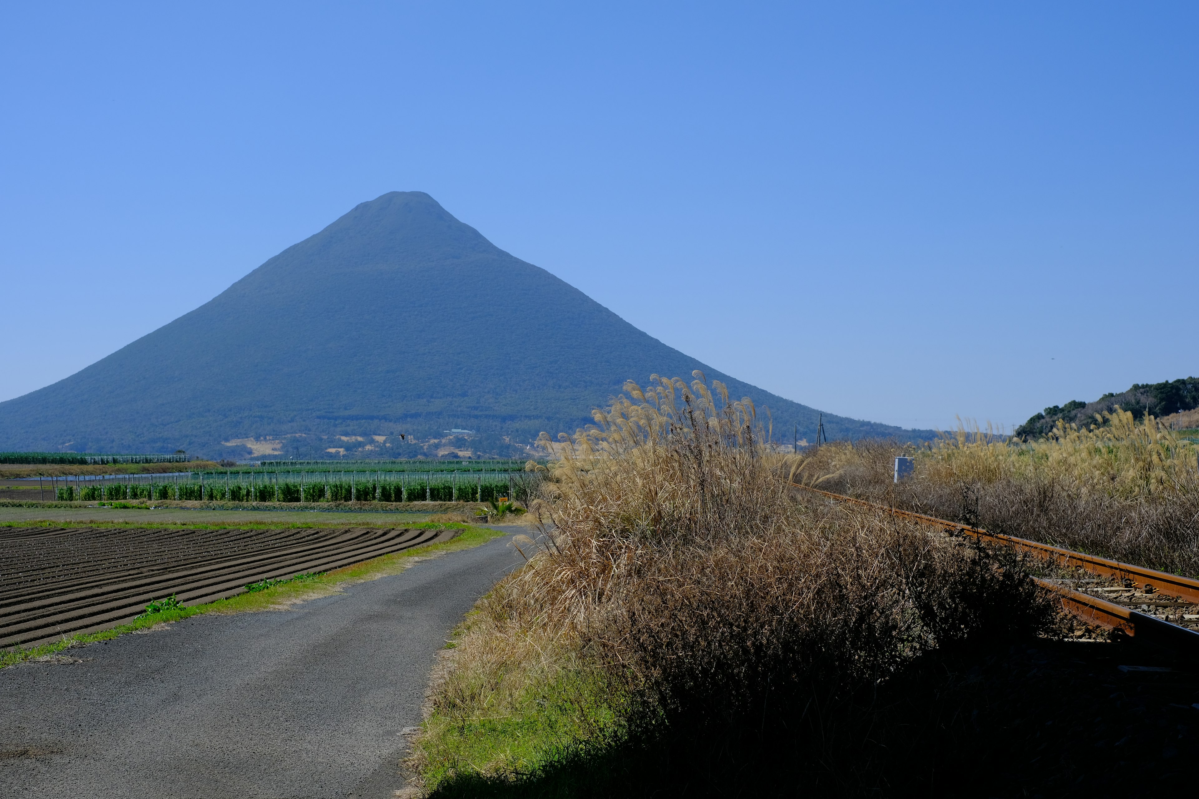 Una bella montagna si erge contro un cielo blu e verdi terreni agricoli