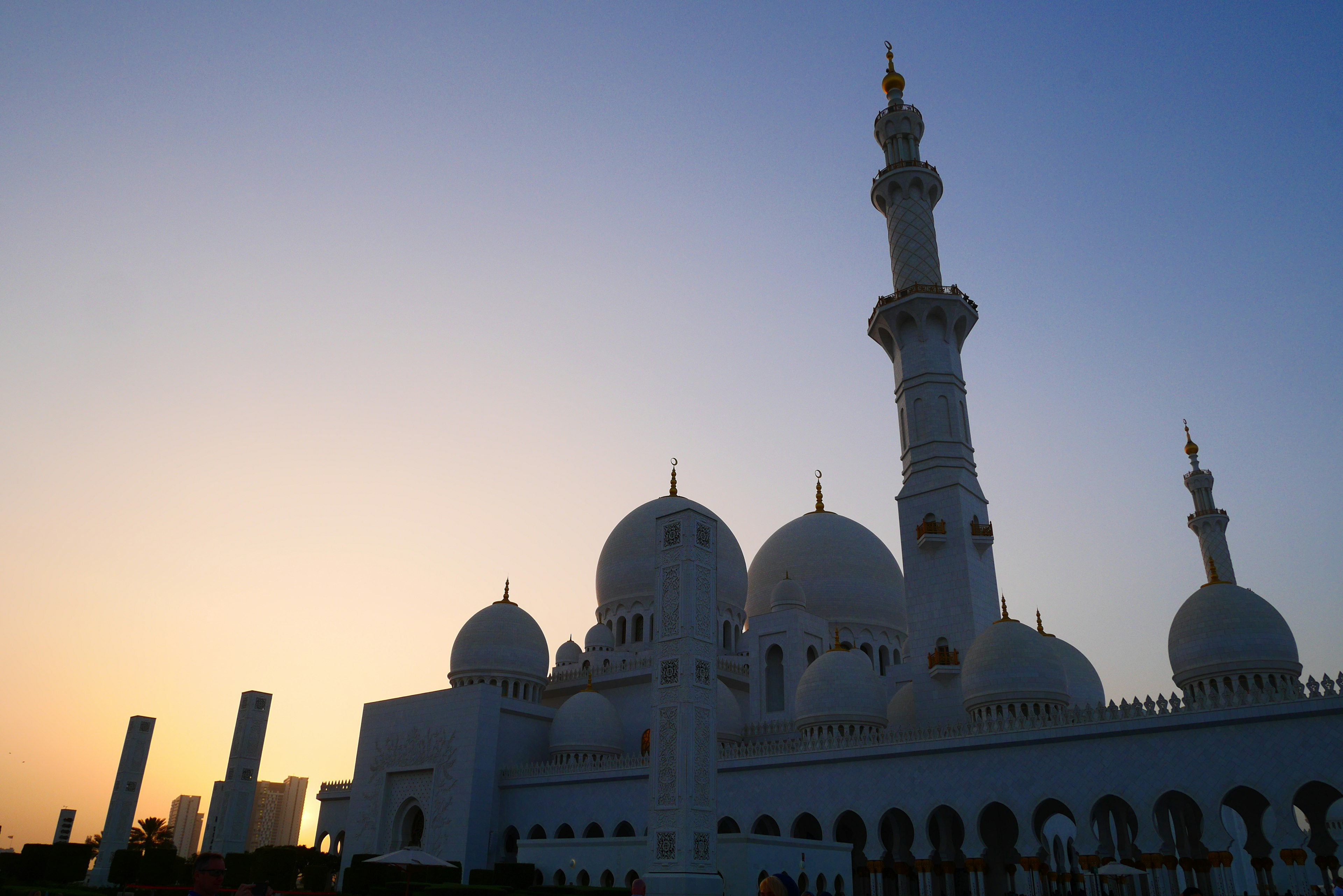 Silhouette of a grand mosque against a sunset sky