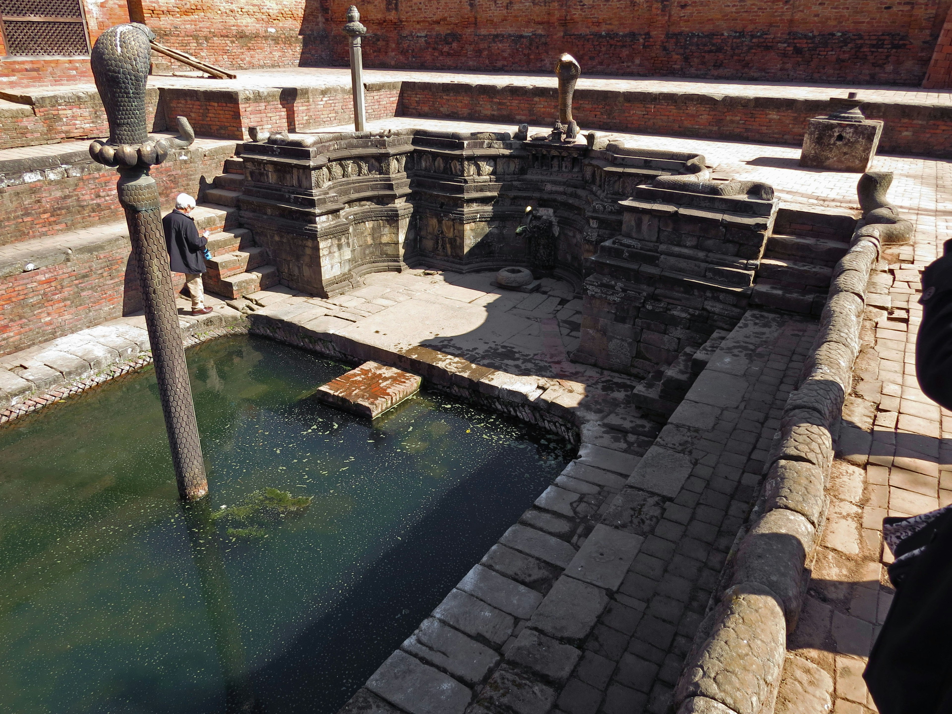 Réservoir d'eau ancien avec des marches en pierre et des piliers