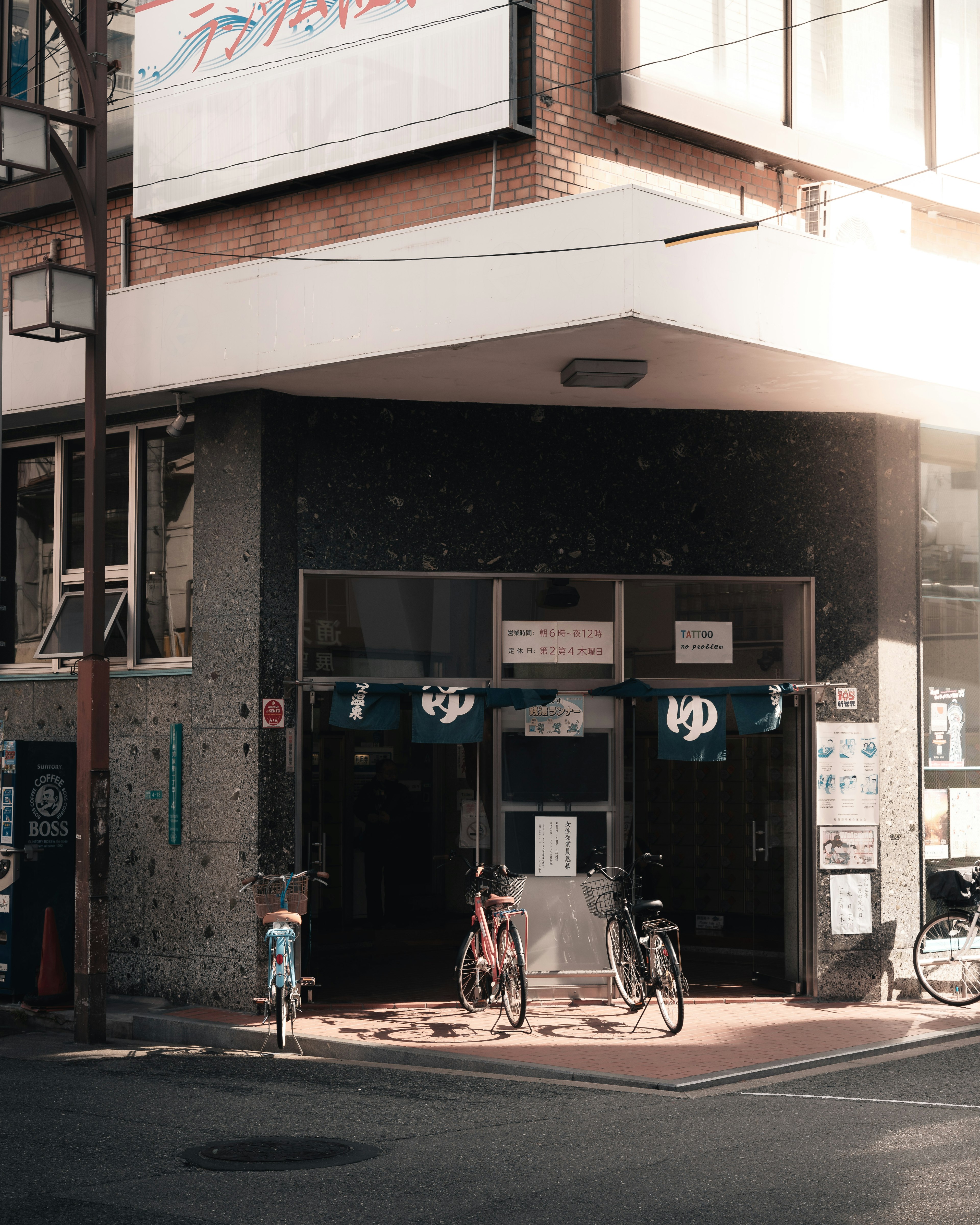 Entrée d'un bâtiment avec des vélos garés à l'extérieur et une signalisation visible