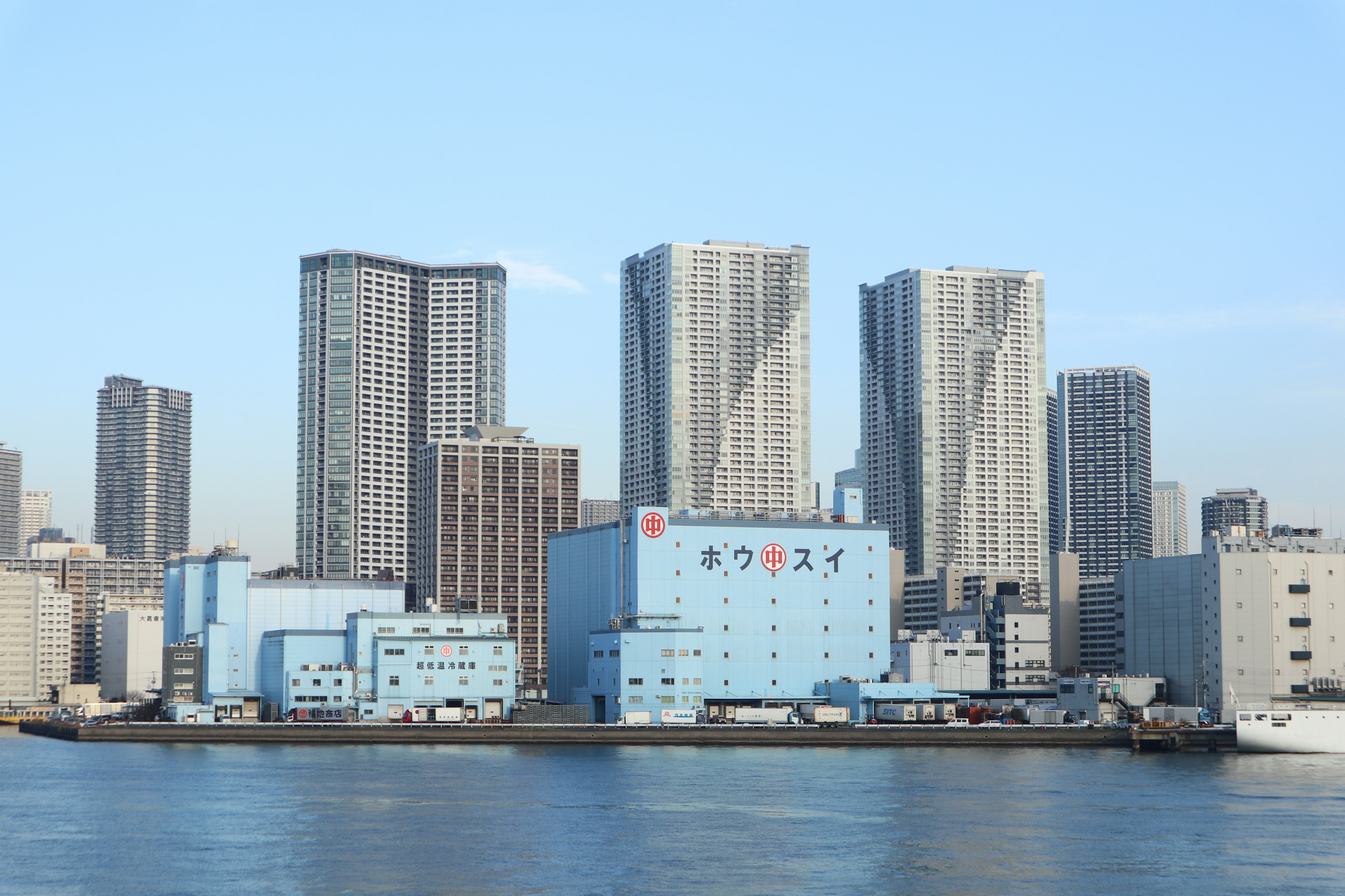 青い建物と高層ビルが並ぶ都市の風景