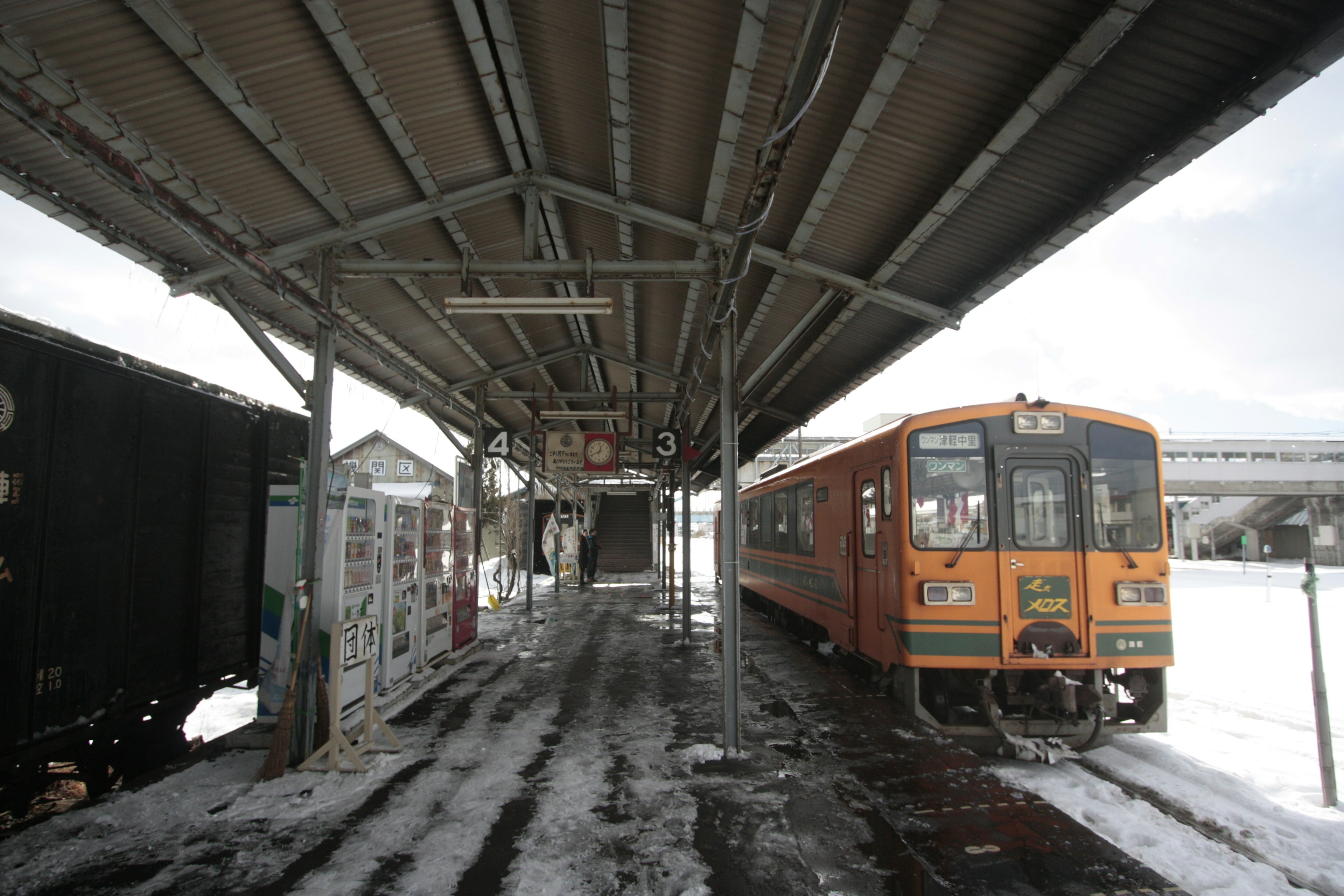 Orange train at a snowy station platform