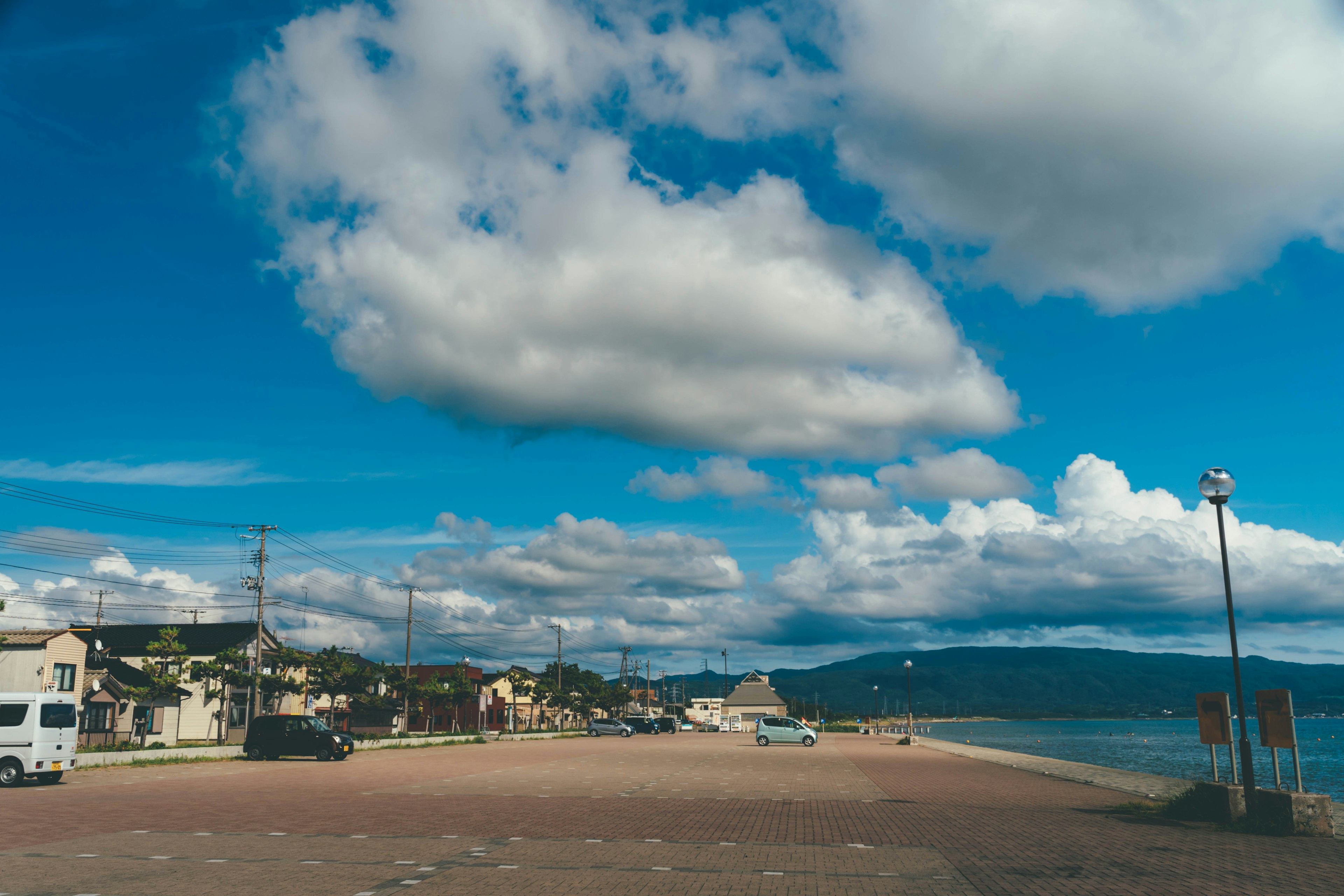 Scène de plage avec ciel bleu et nuages présentant une plage de sable et une côte