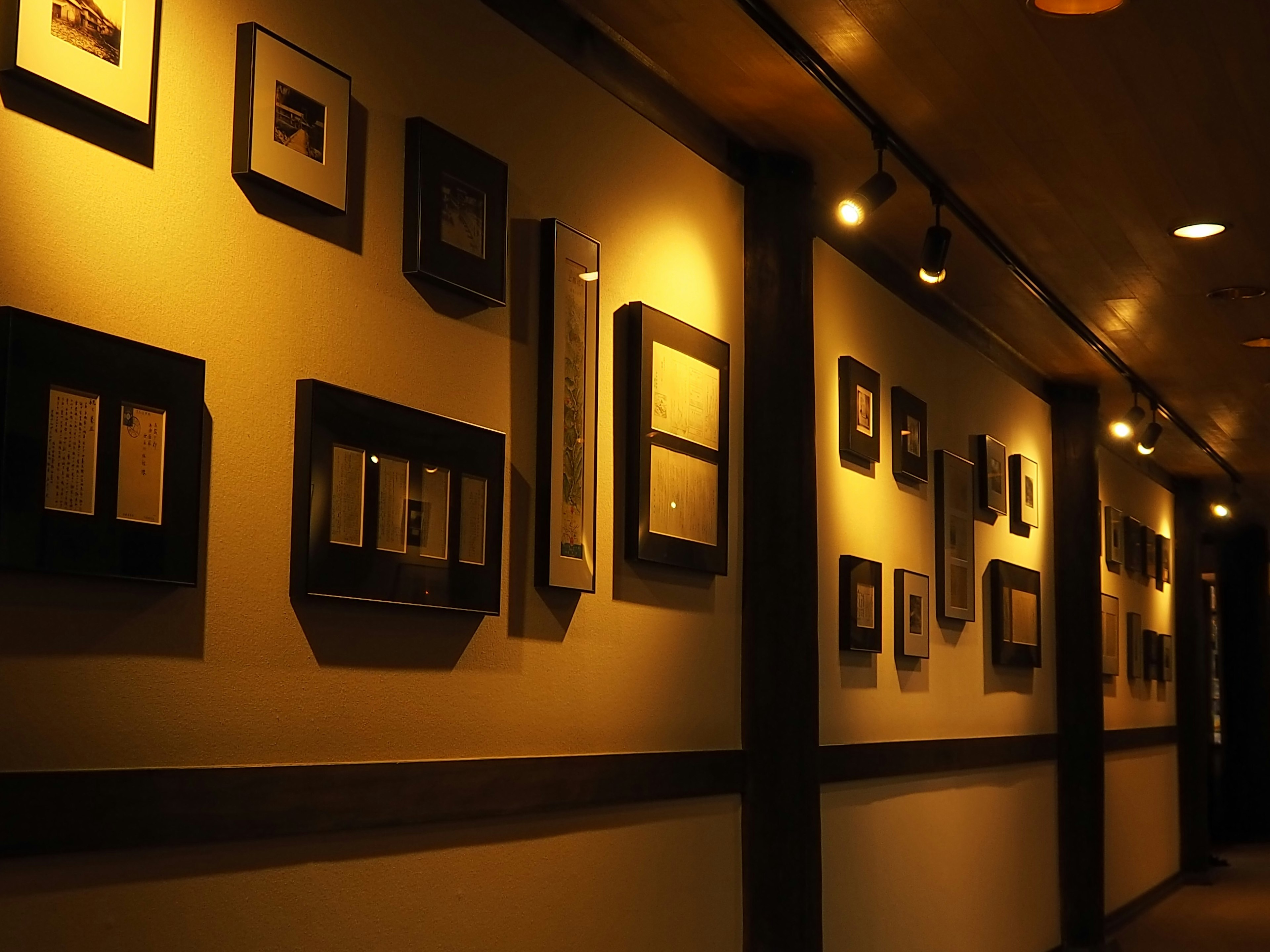 Gallery display along a wall featuring black-framed photographs