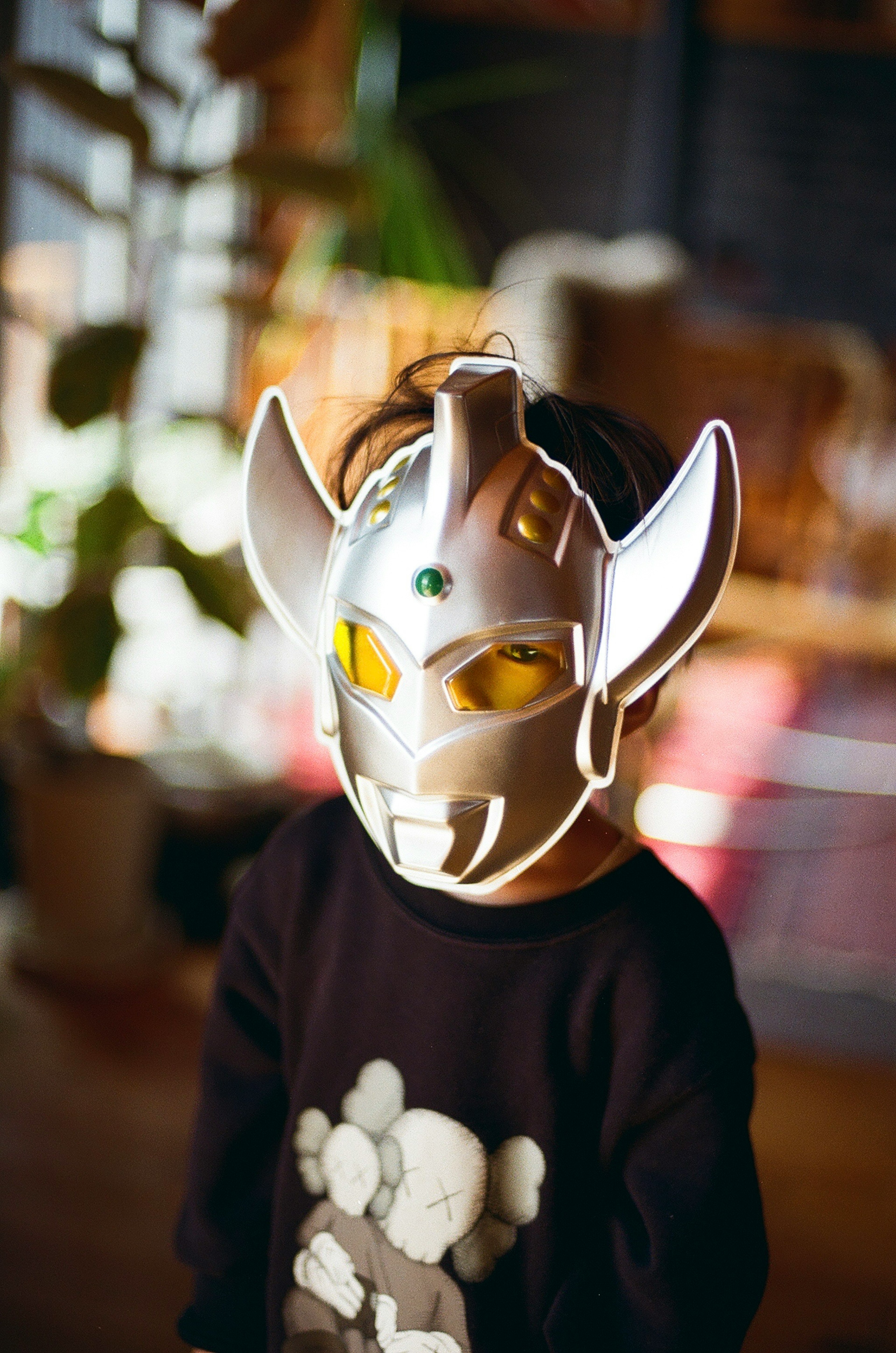 Kind trägt eine silberne Maske drinnen