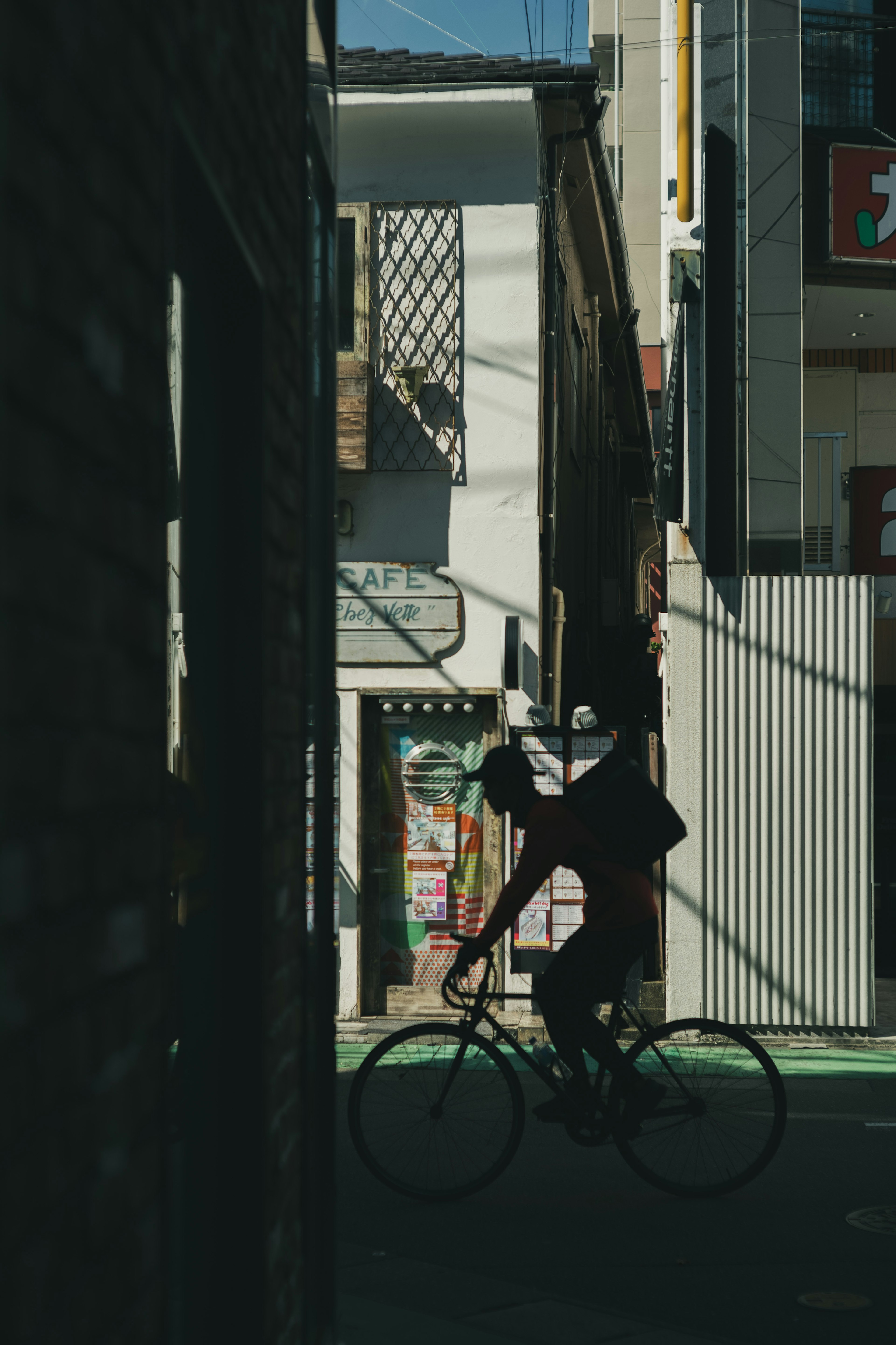 Silhouette di una persona in bicicletta in una strada stretta