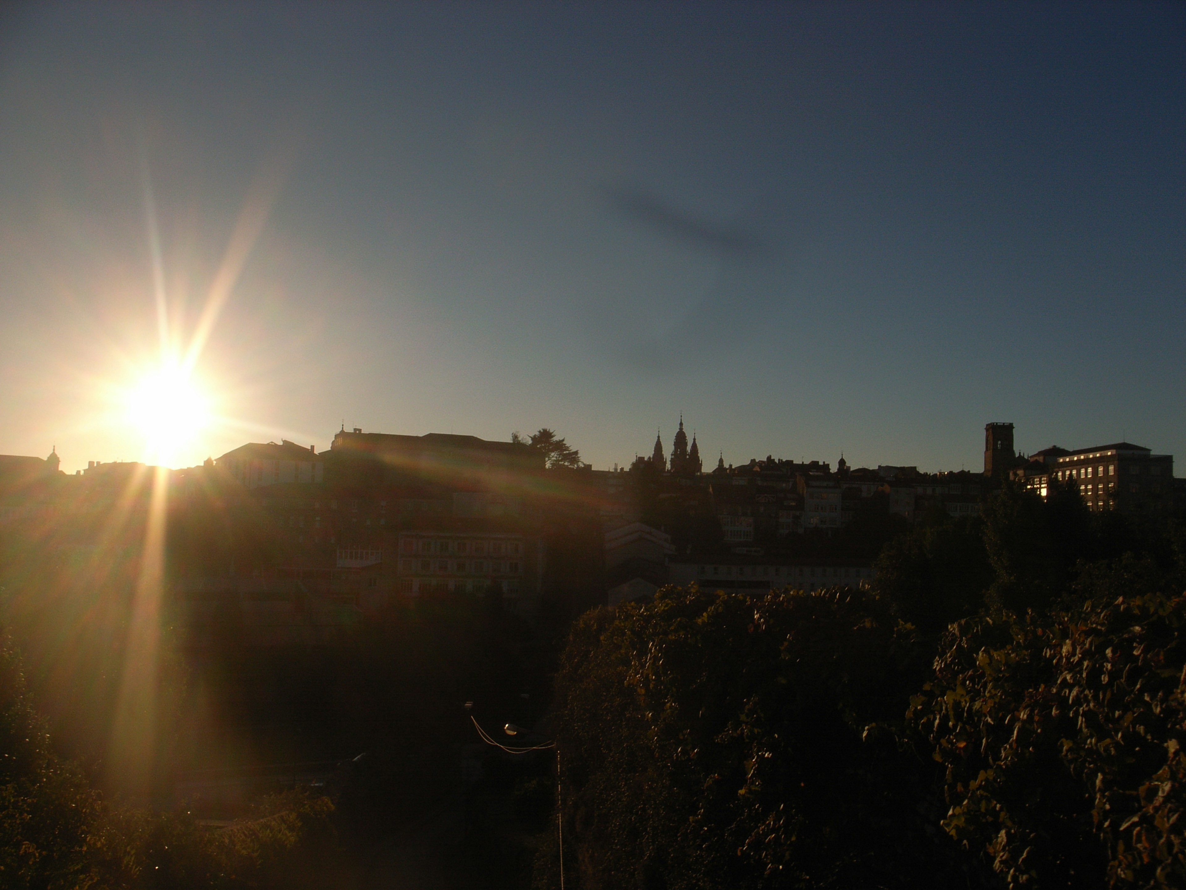 Sunrise over a city skyline with silhouetted buildings