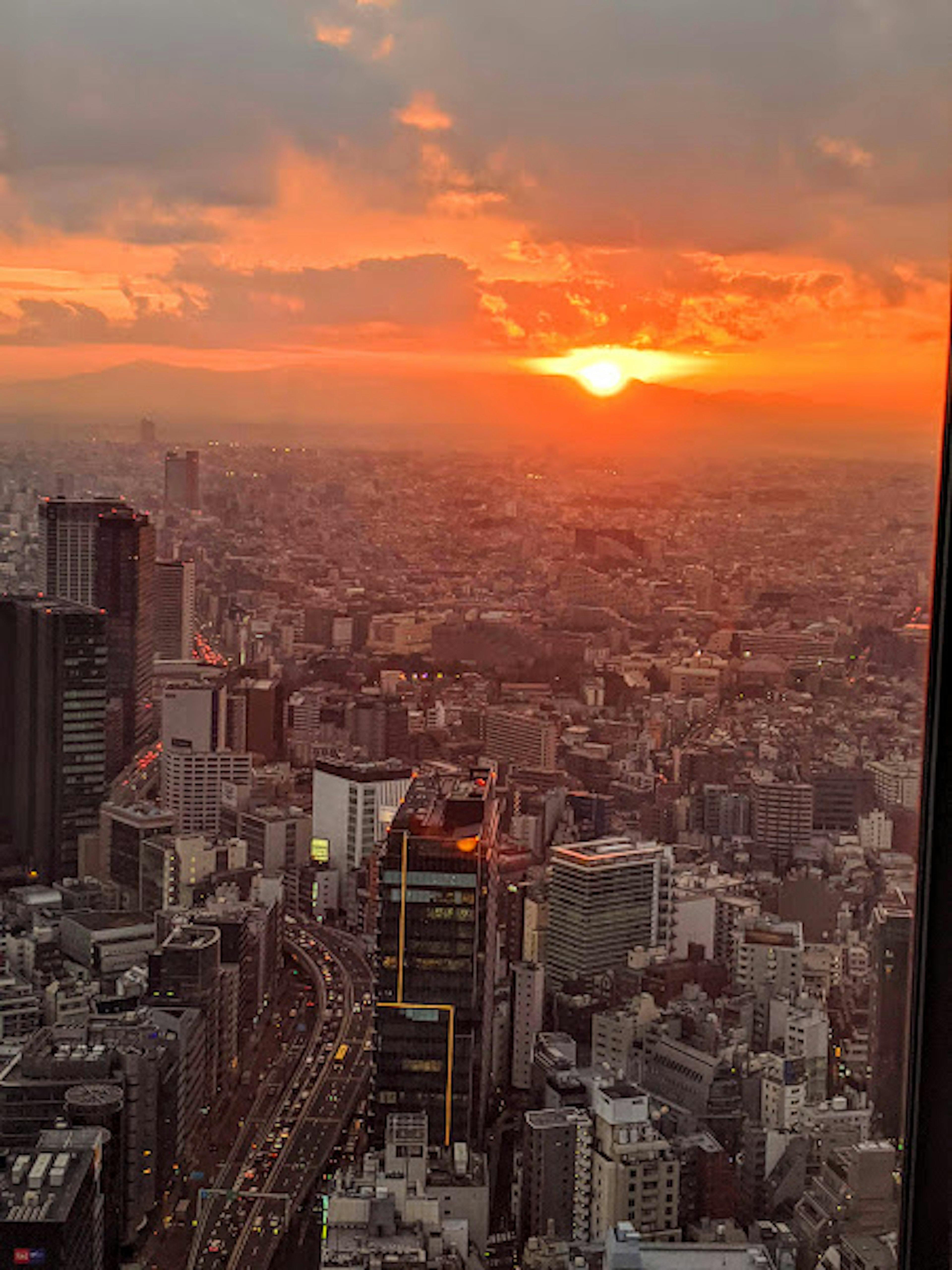 Pemandangan panoramik Tokyo saat matahari terbenam dengan langit oranye cerah