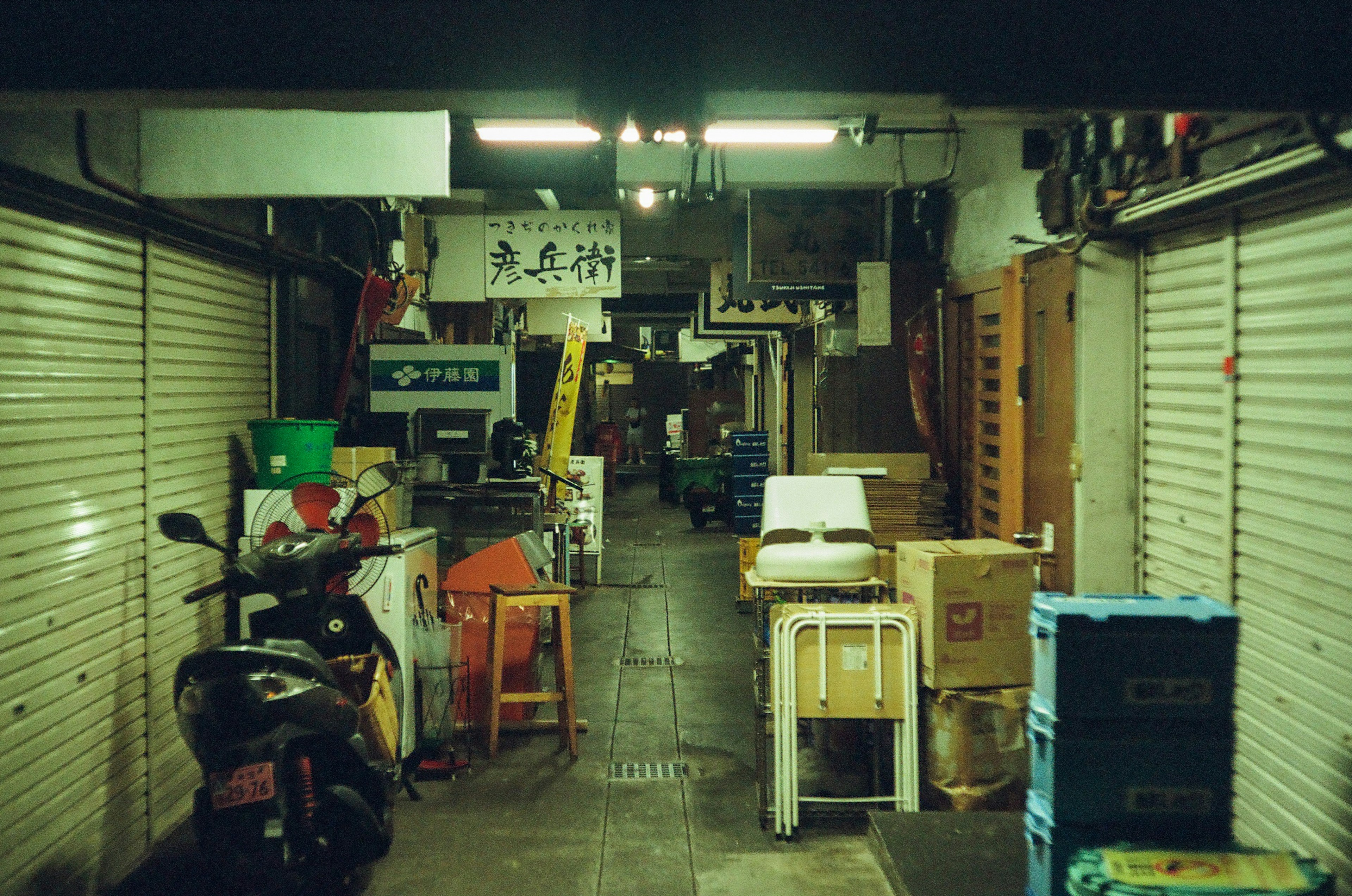 Narrow corridor filled with various items and shutters