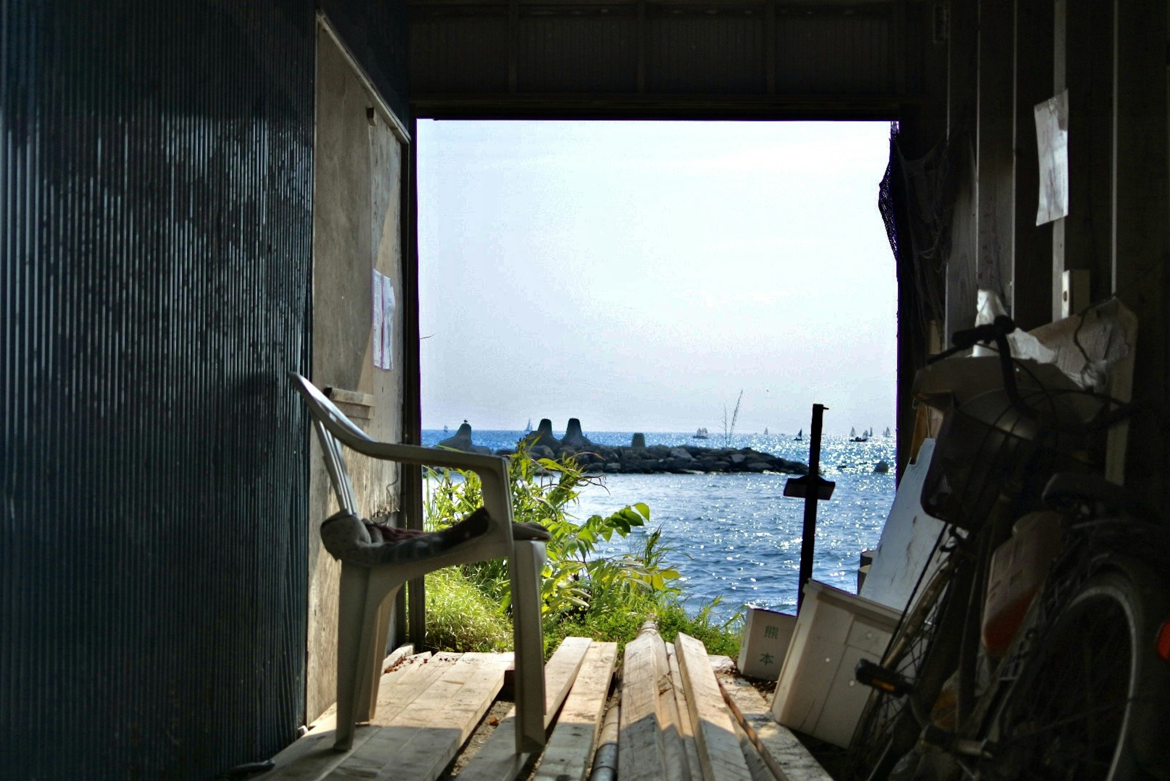 Interior of a hut with a chair and bicycle overlooking the sea