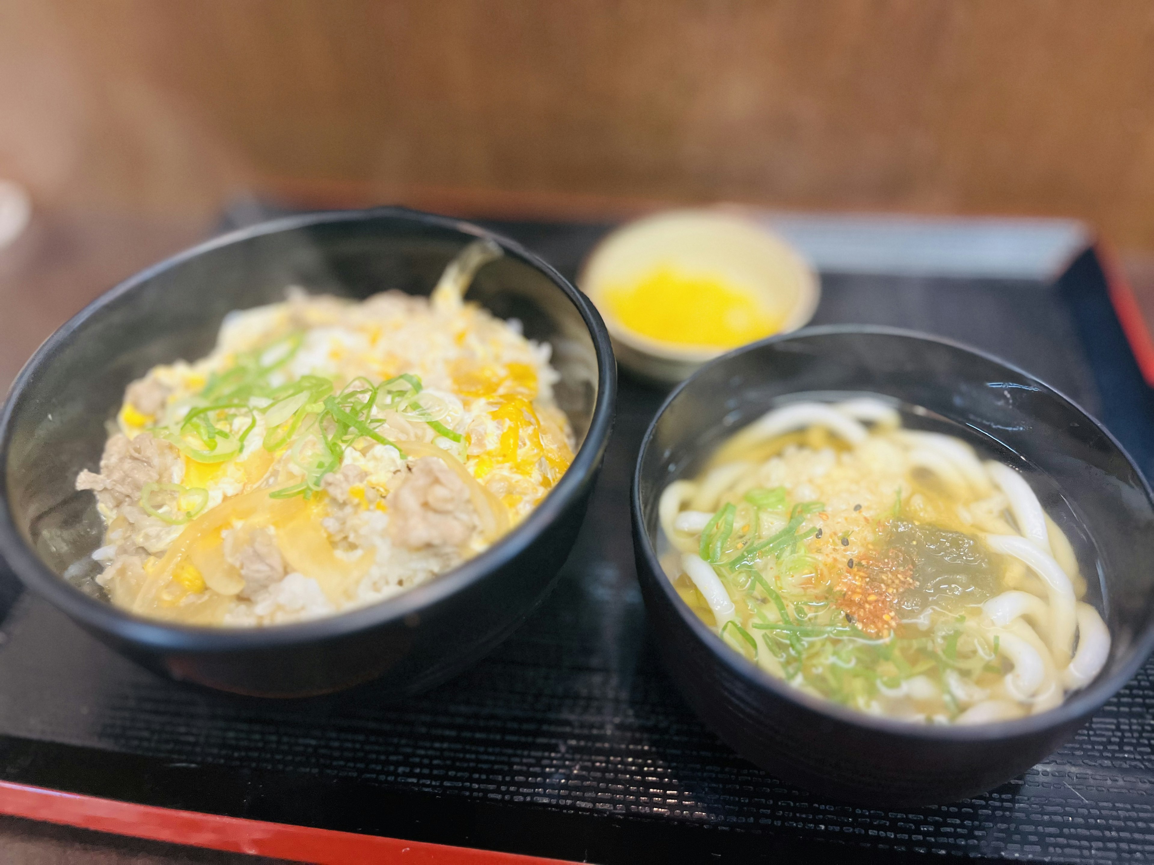 Mangkuk nasi panas dengan mie udon disajikan di atas nampan