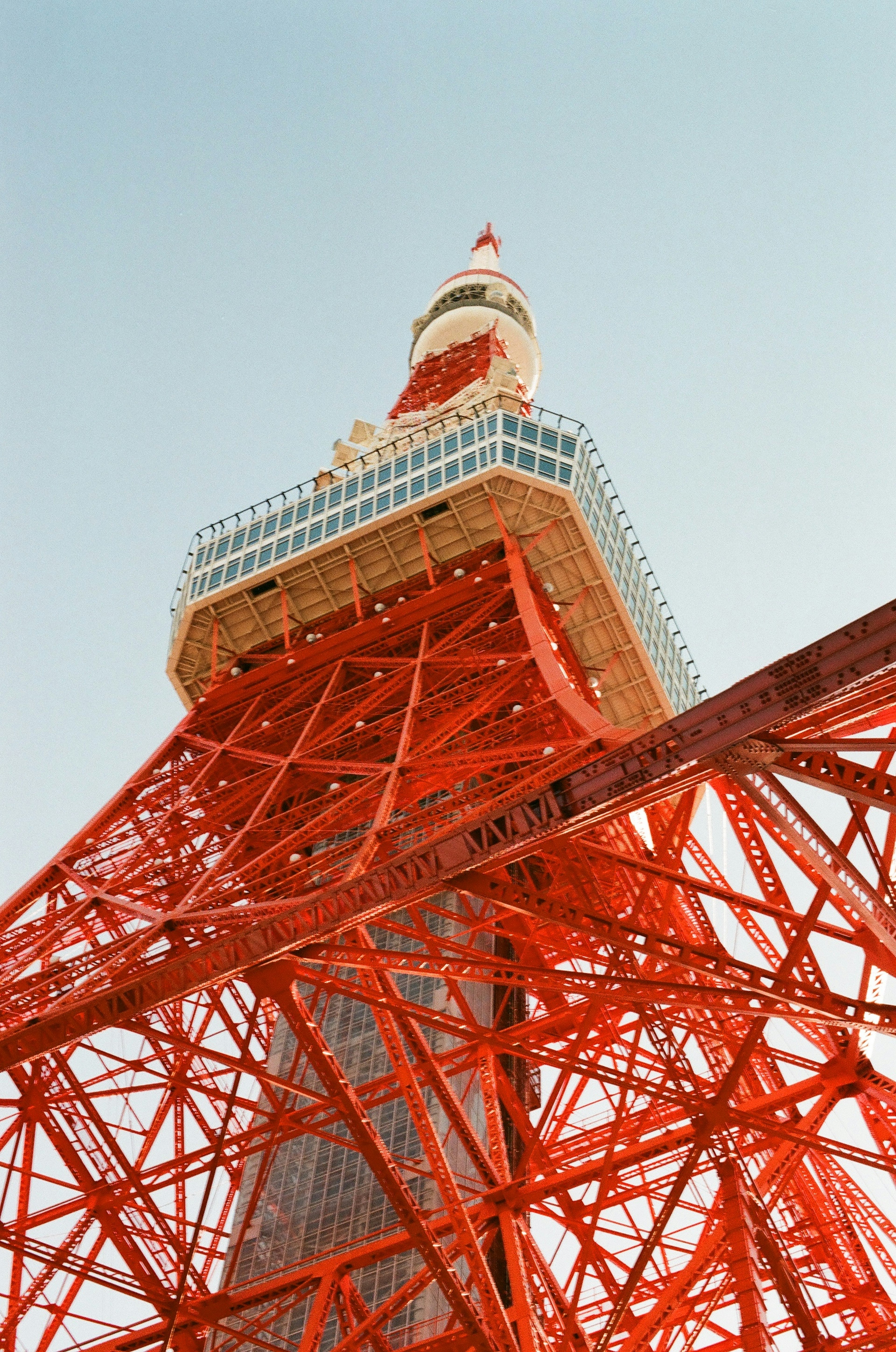 從下方仰望東京塔展示其紅色鋼結構與藍天