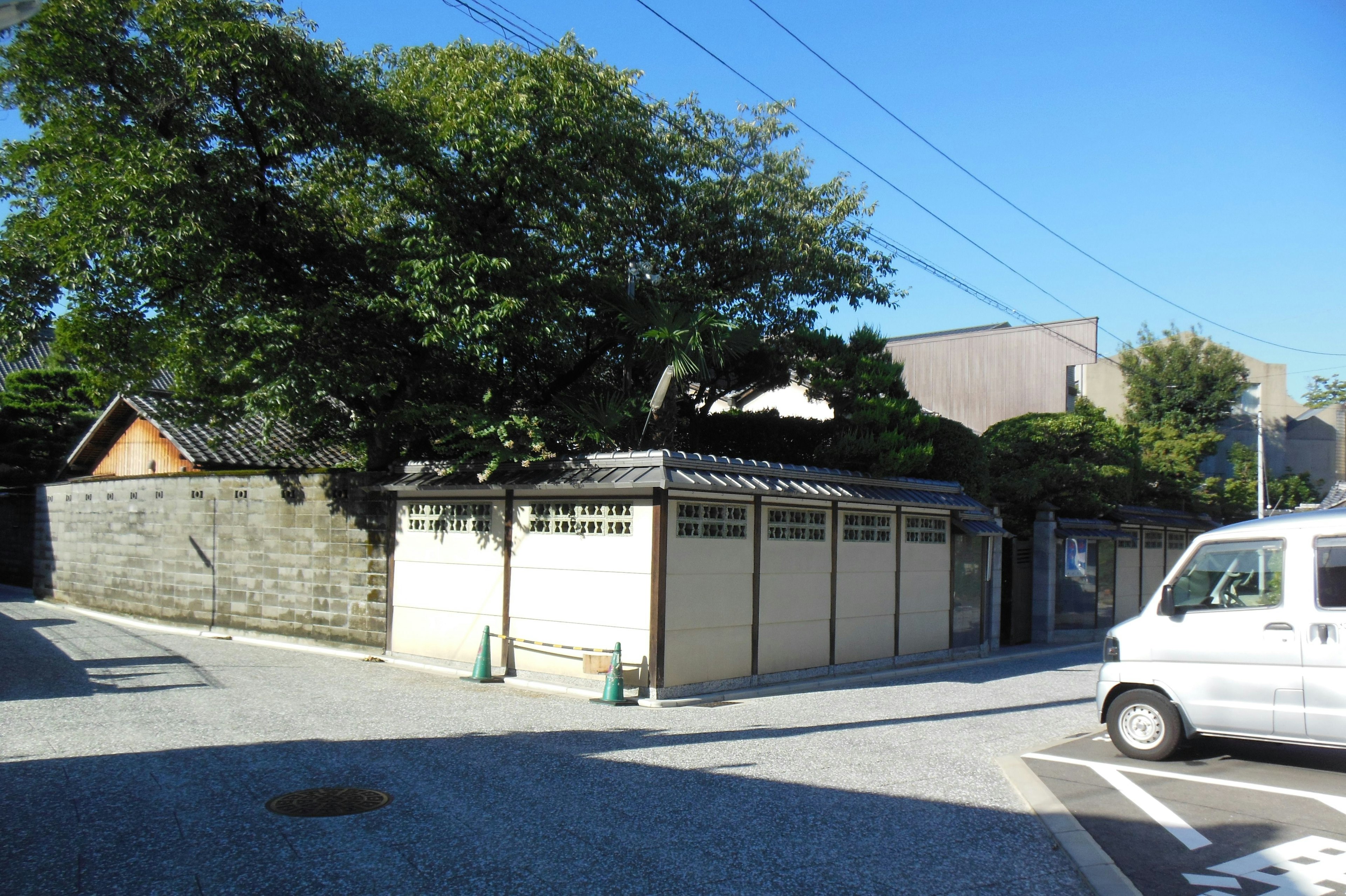 Traditional Japanese house at a quiet street corner with trees